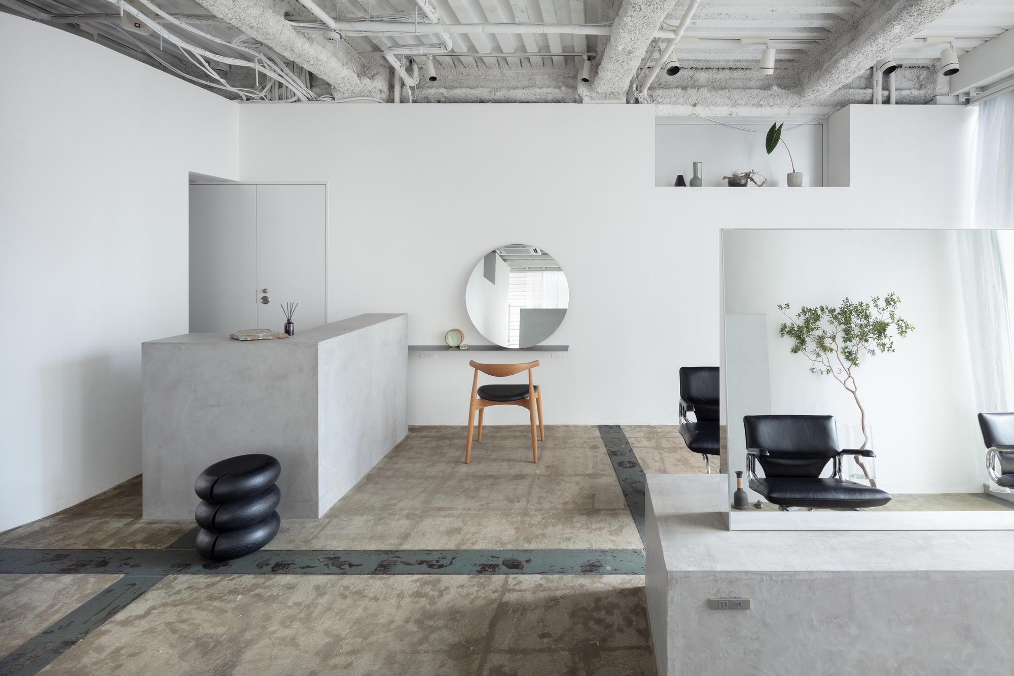 Split-level interior with concrete platforms and exposed ceiling beams under diffused daylight