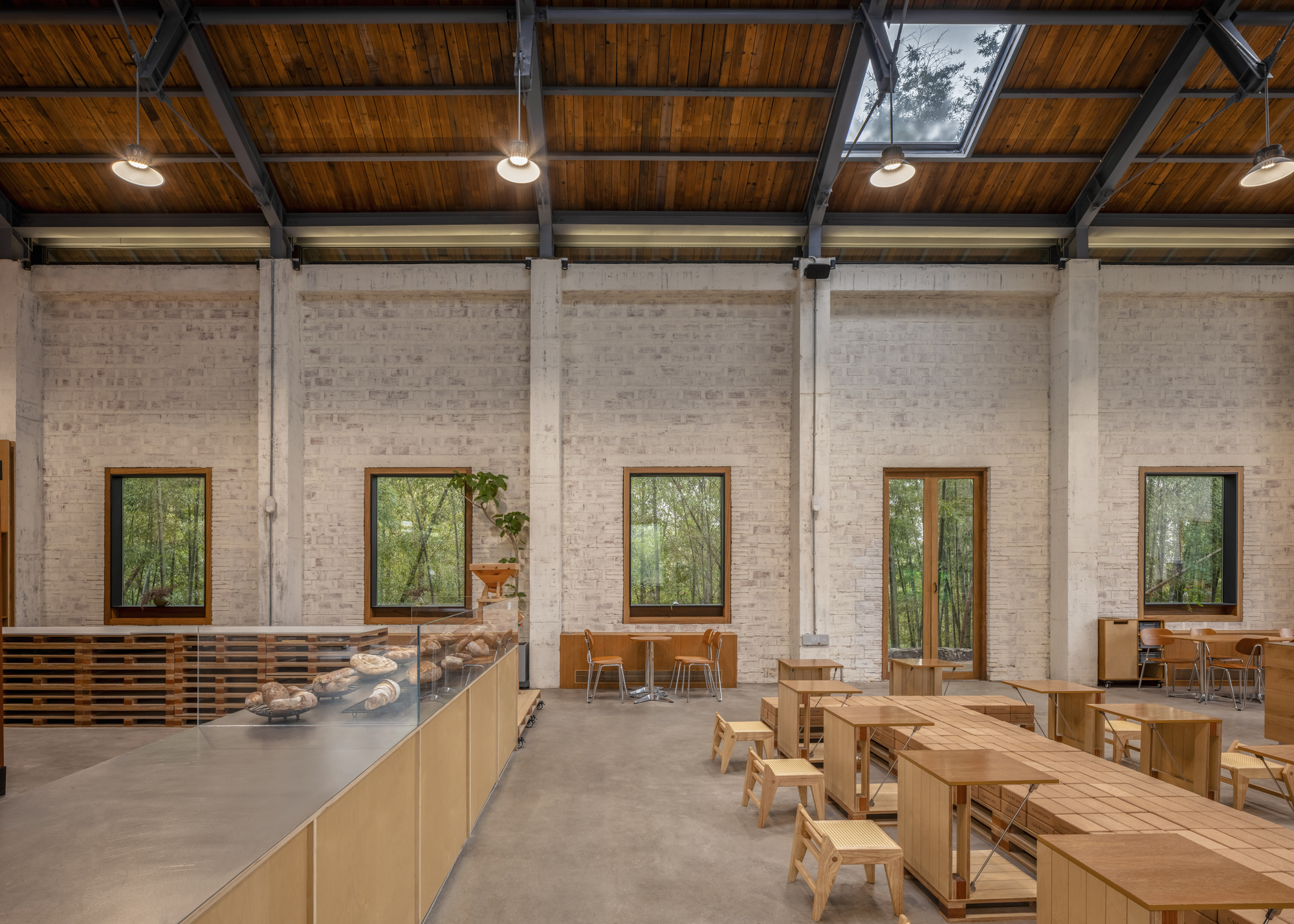 White brick wall with timber-framed windows and polished concrete floor in afternoon light