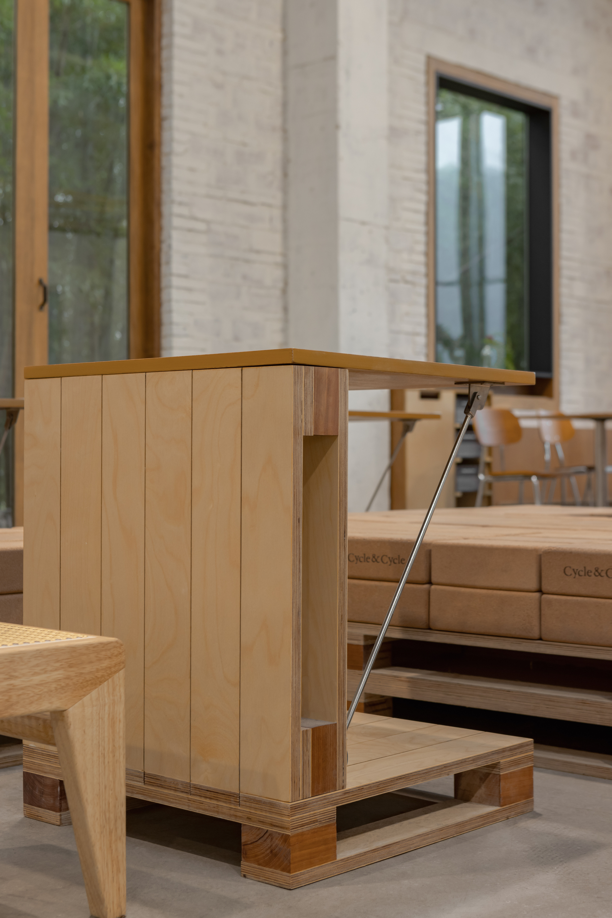 Corner detail of timber display cabinet with vertical slat cladding on polished concrete floor