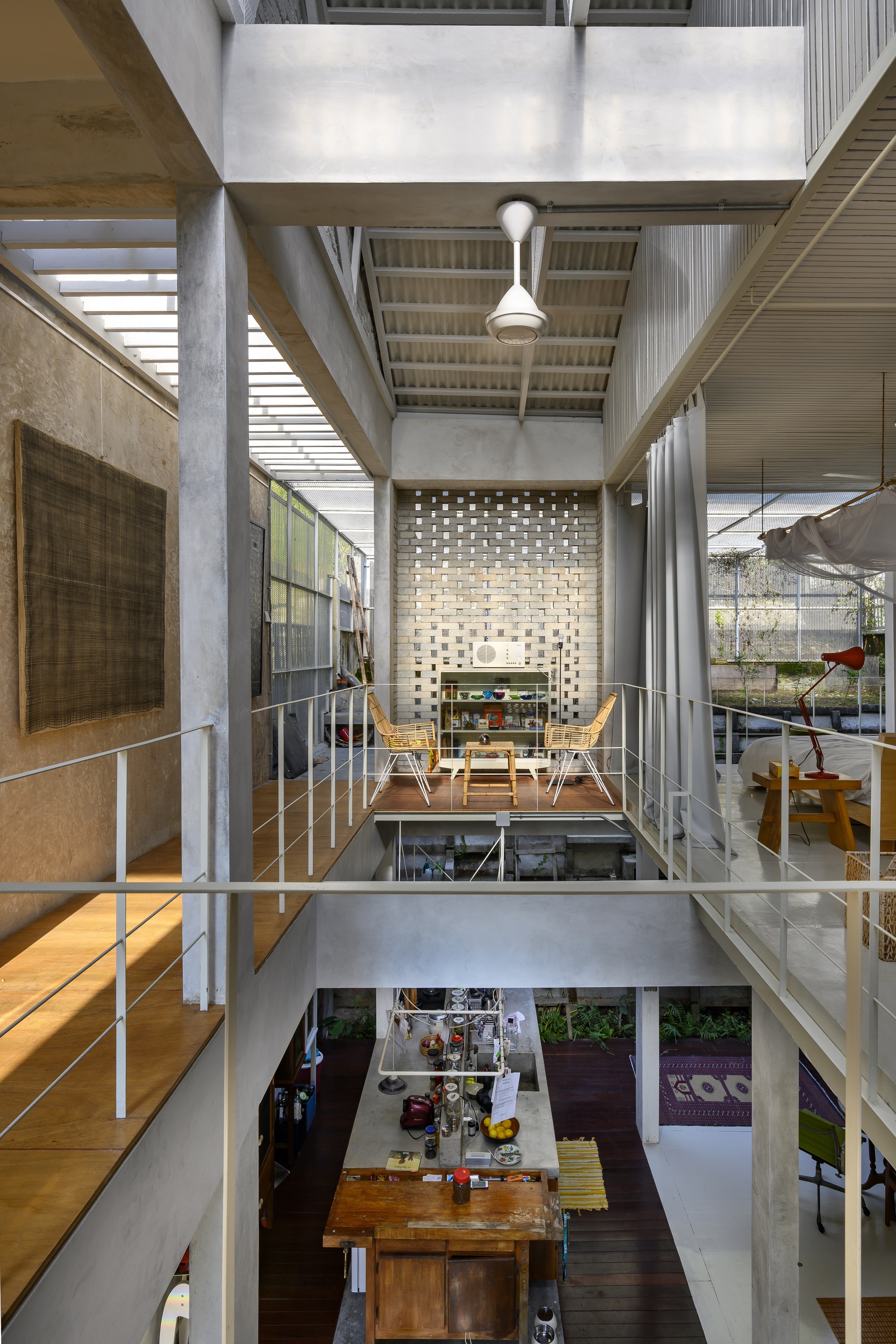 Vertical section through multi-level interior showing perforated brick screen, bridges, and open dining space below