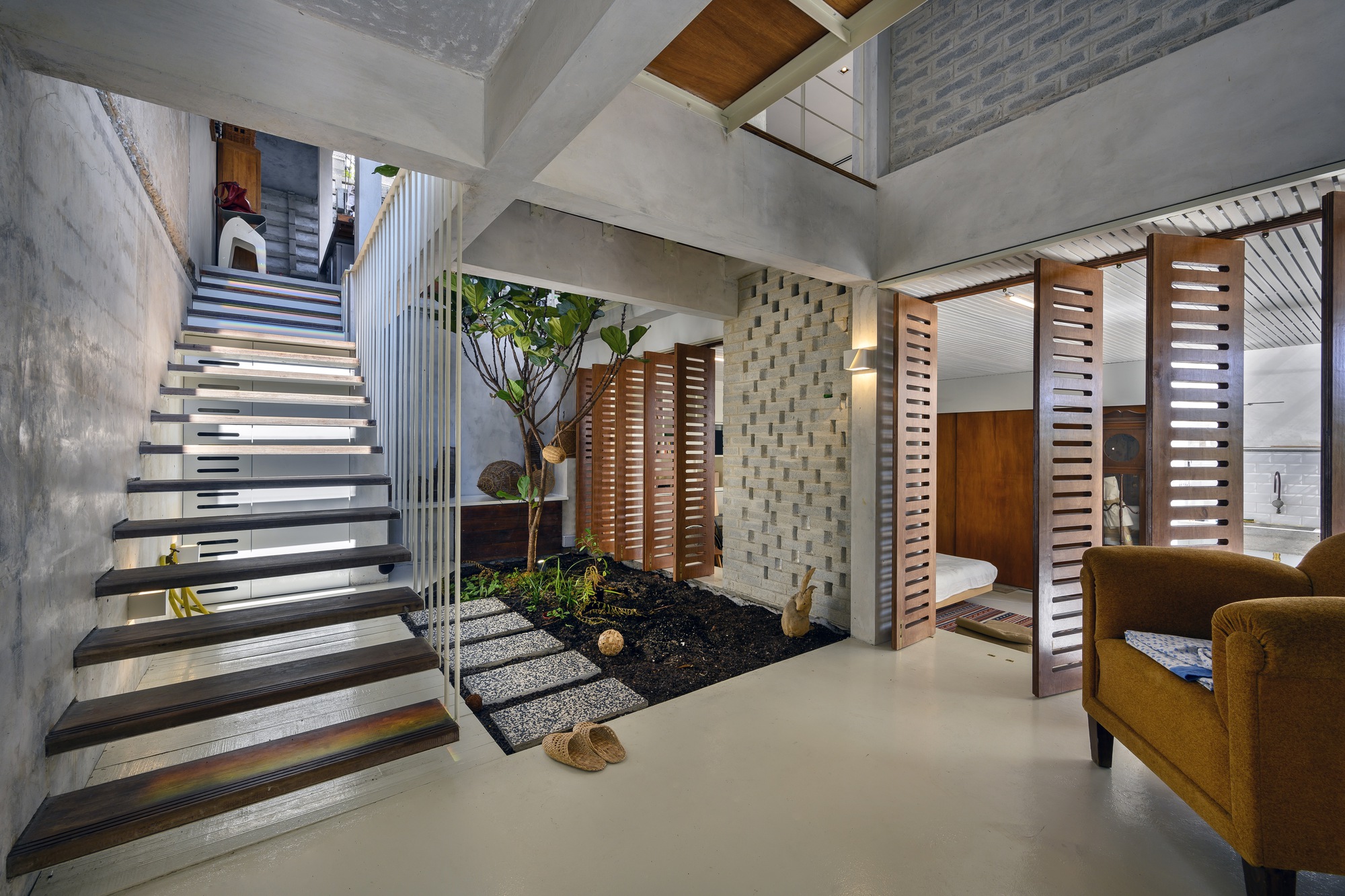 Ground floor courtyard with open-tread staircase, indoor planting bed and pivoting timber louvered screens