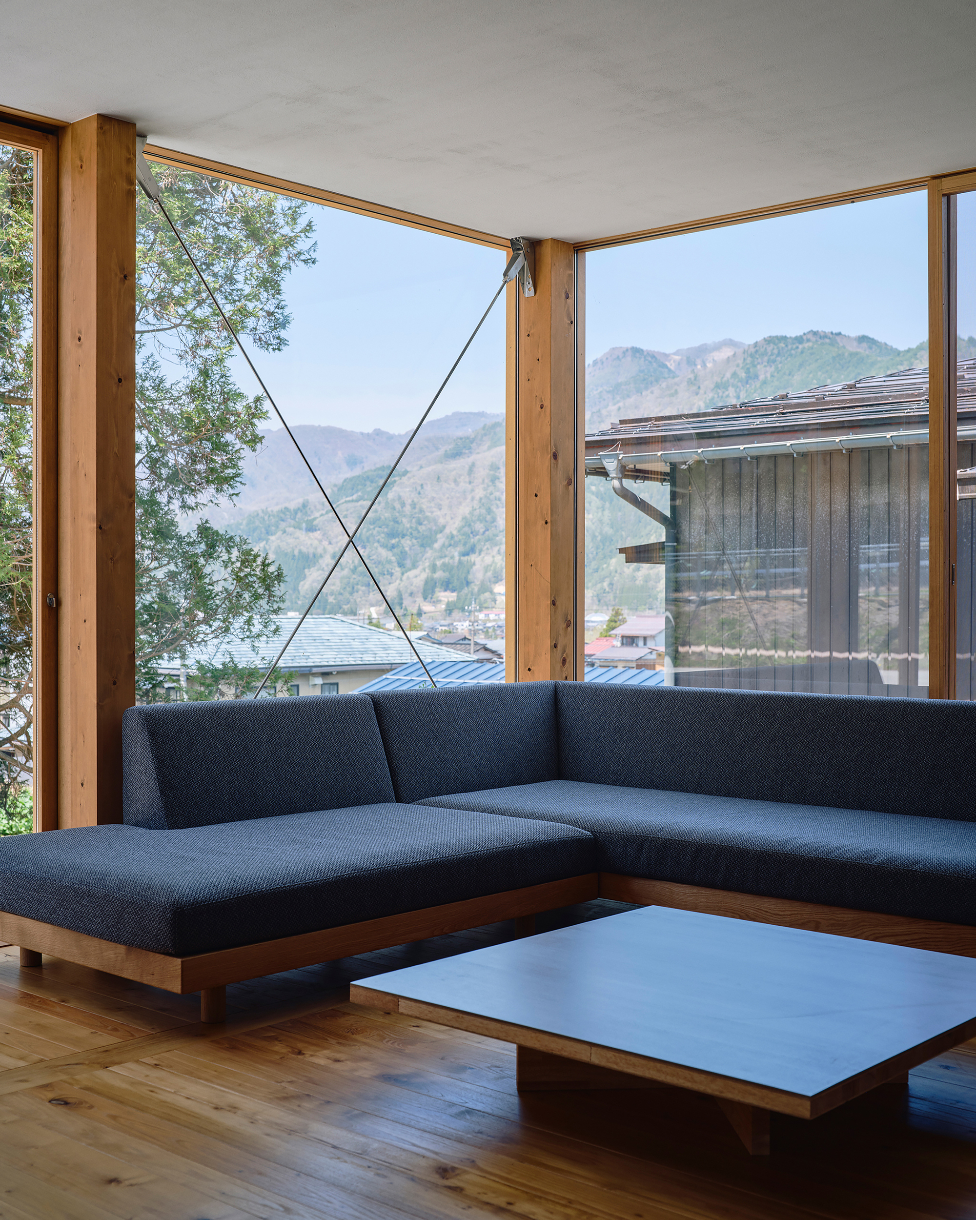 Corner glazing framing mountain views with timber columns and cable bracing