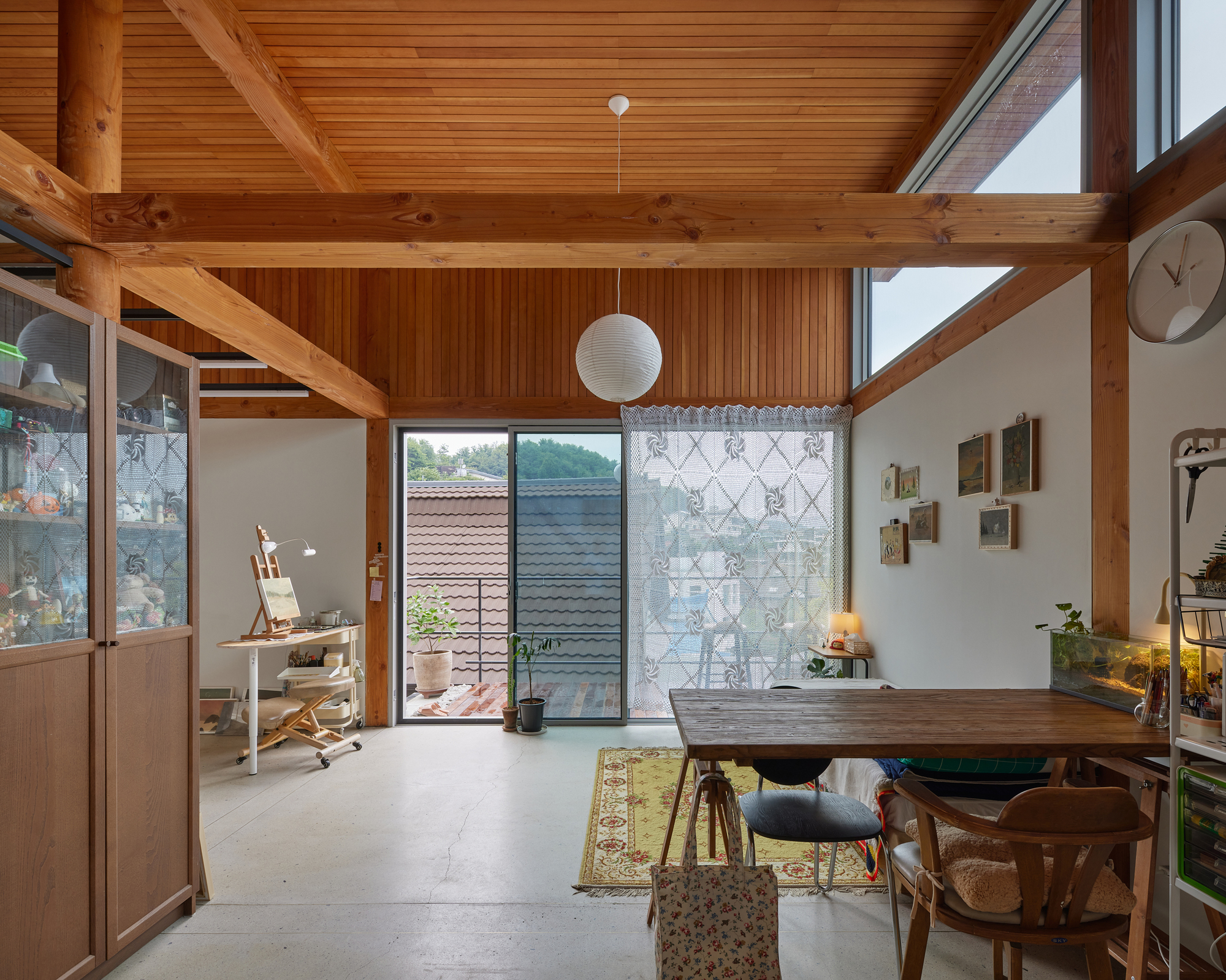 Interior with exposed timber beams and ceiling opening to a patterned screen wall and courtyard beyond