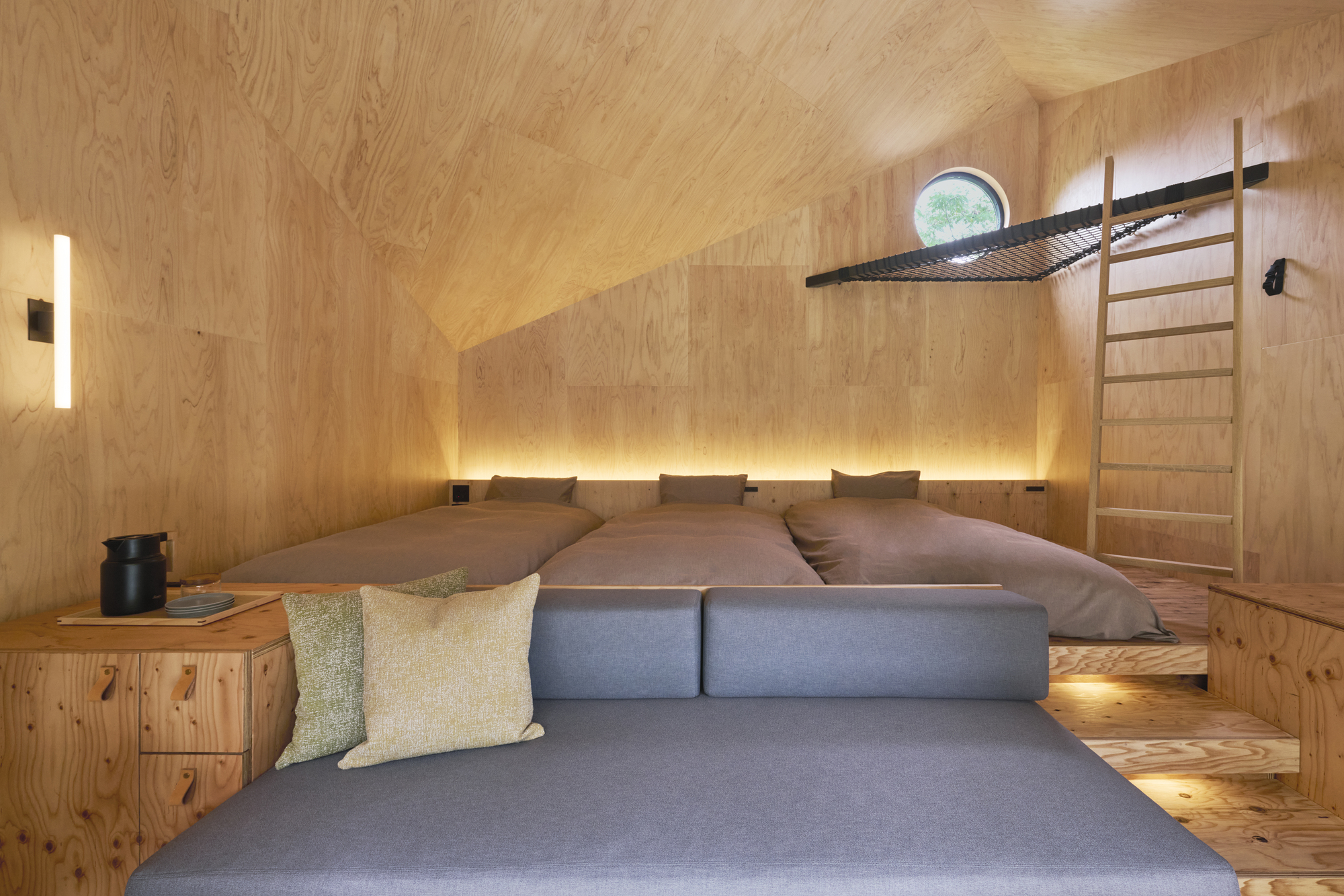 Interior view of gabled sleeping loft with continuous strip lighting beneath the bed platform