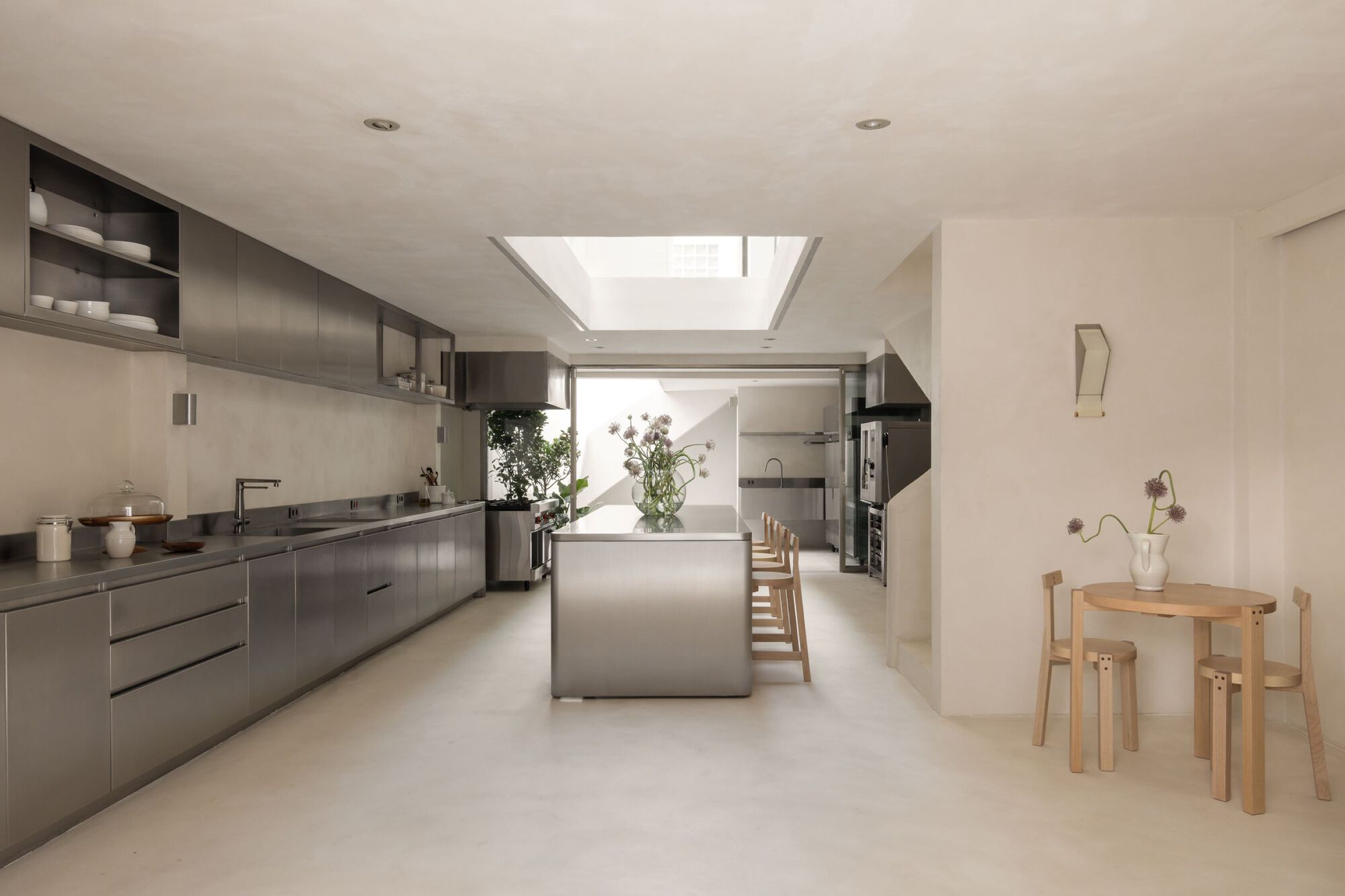 Open kitchen with stainless steel cabinetry and island beneath a rectangular skylight