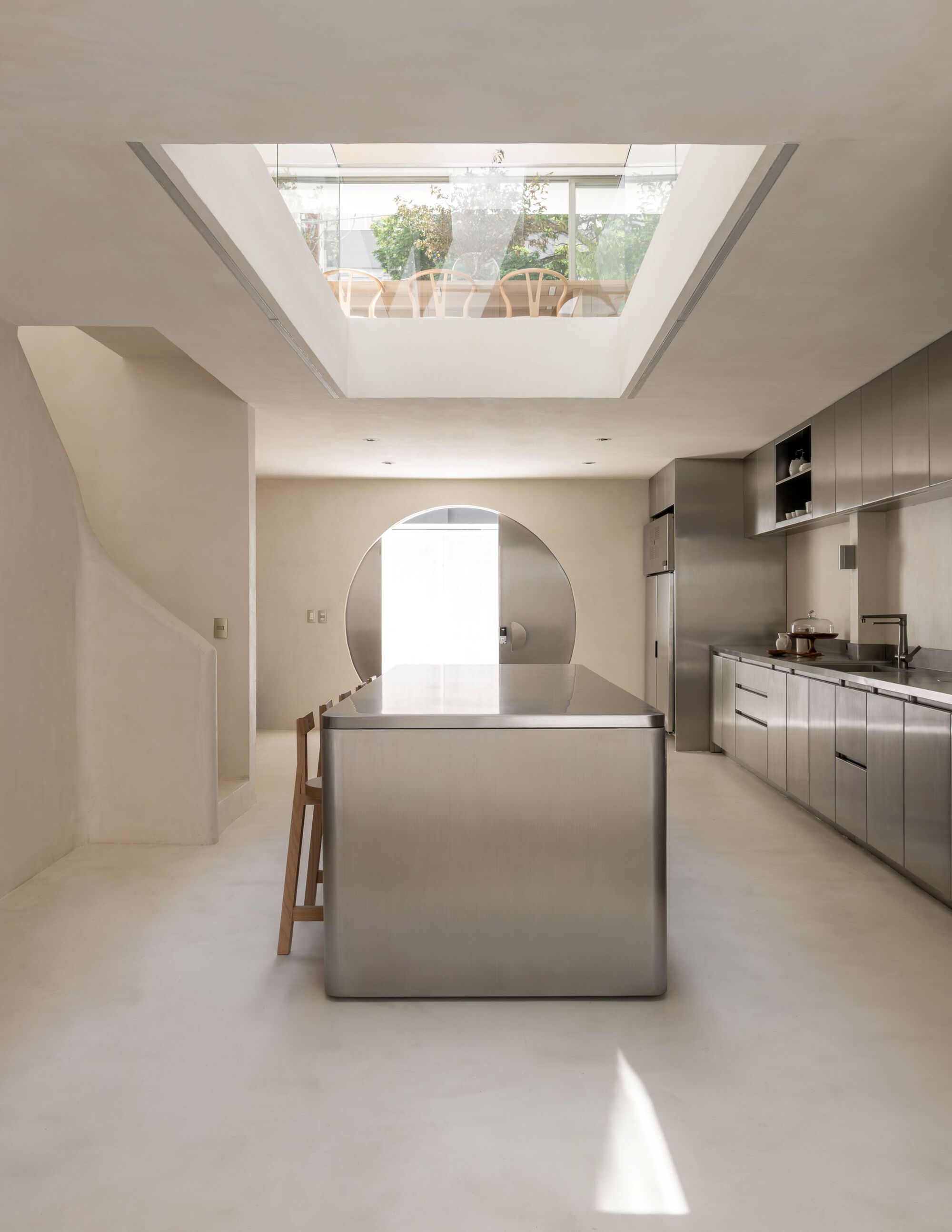 Kitchen island beneath a rectangular skylight framing a view of the rooftop terrace above