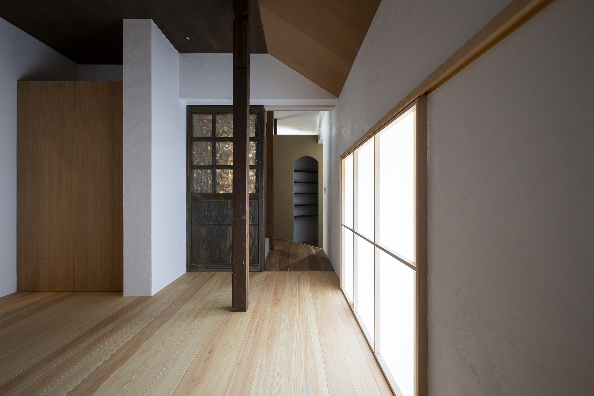 Upper floor hallway with translucent panel wall and exposed timber column at the turn