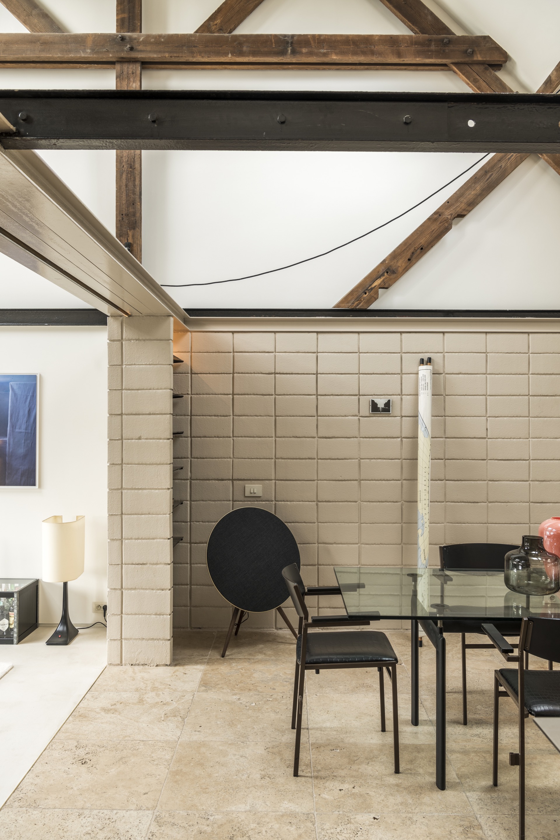 Cream rectangular tile wall with exposed timber roof trusses and steel beams overhead