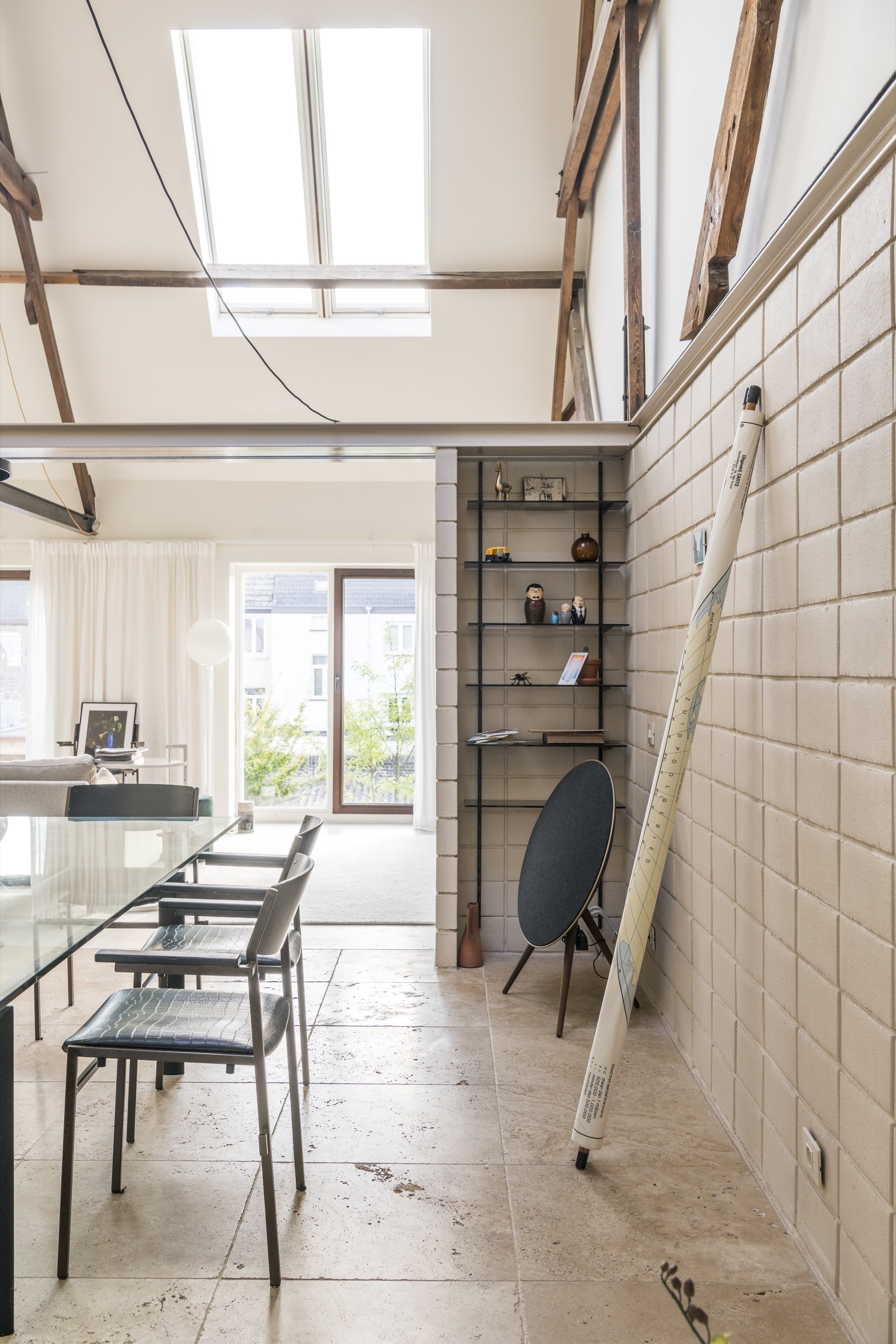 Dining space with tiled walls and ladder propped against the surface under roof skylights