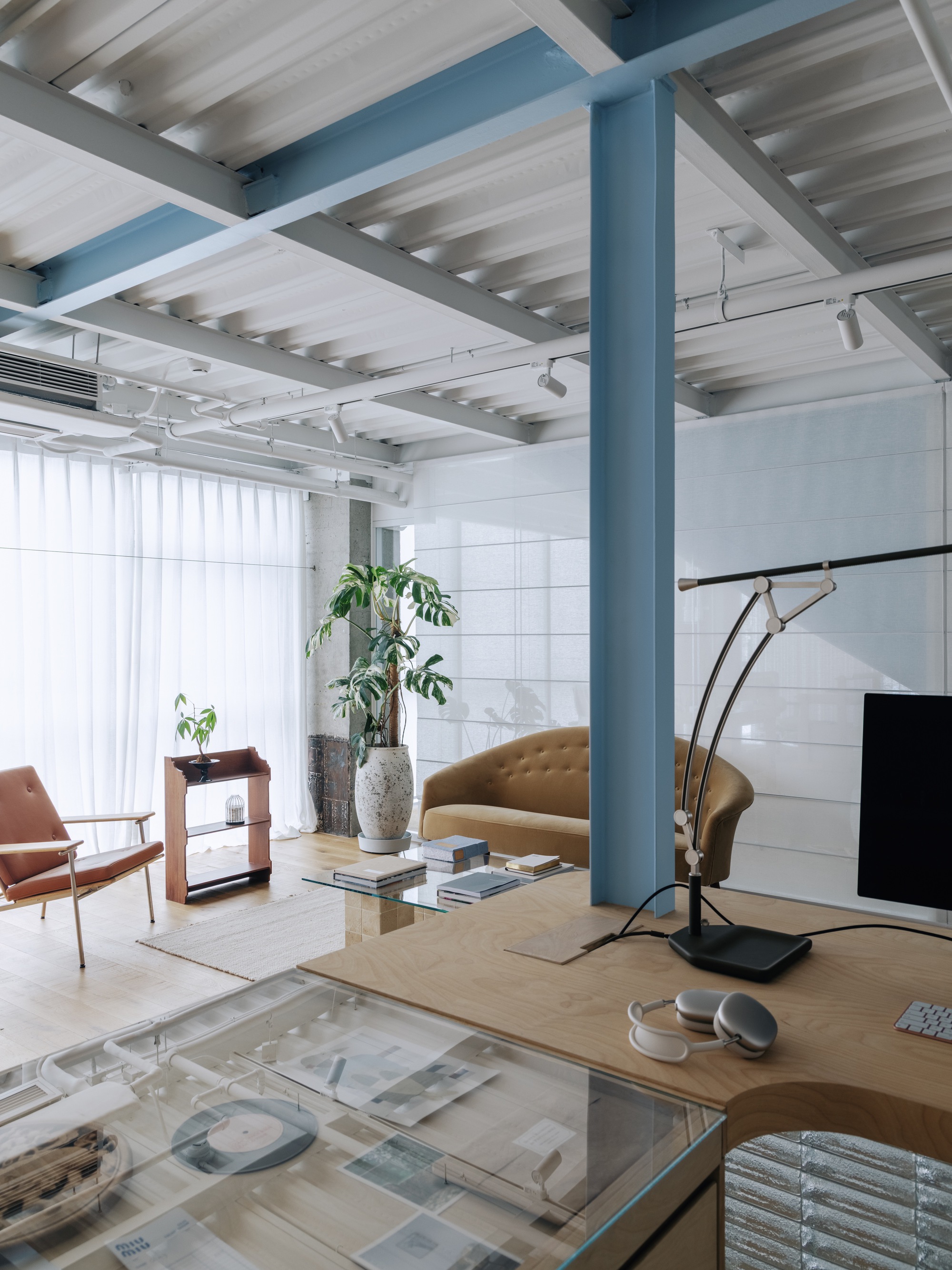 Interior view showing blue column framing a seating area with potted plants near white tiled wall