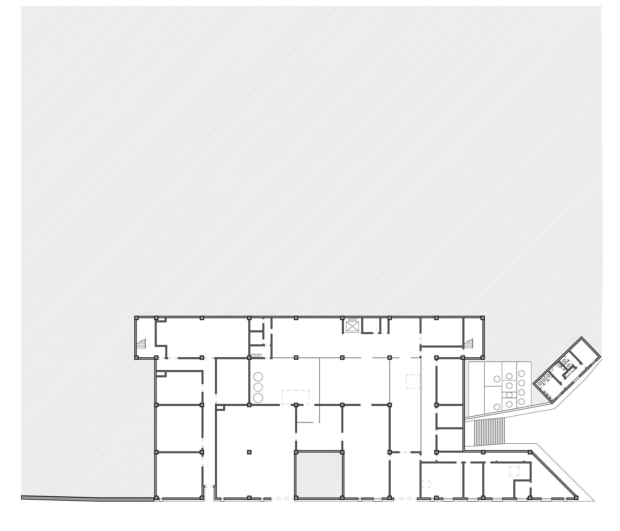Floor plan drawing showing a rectangular volume with multiple rooms and an angled extension wing