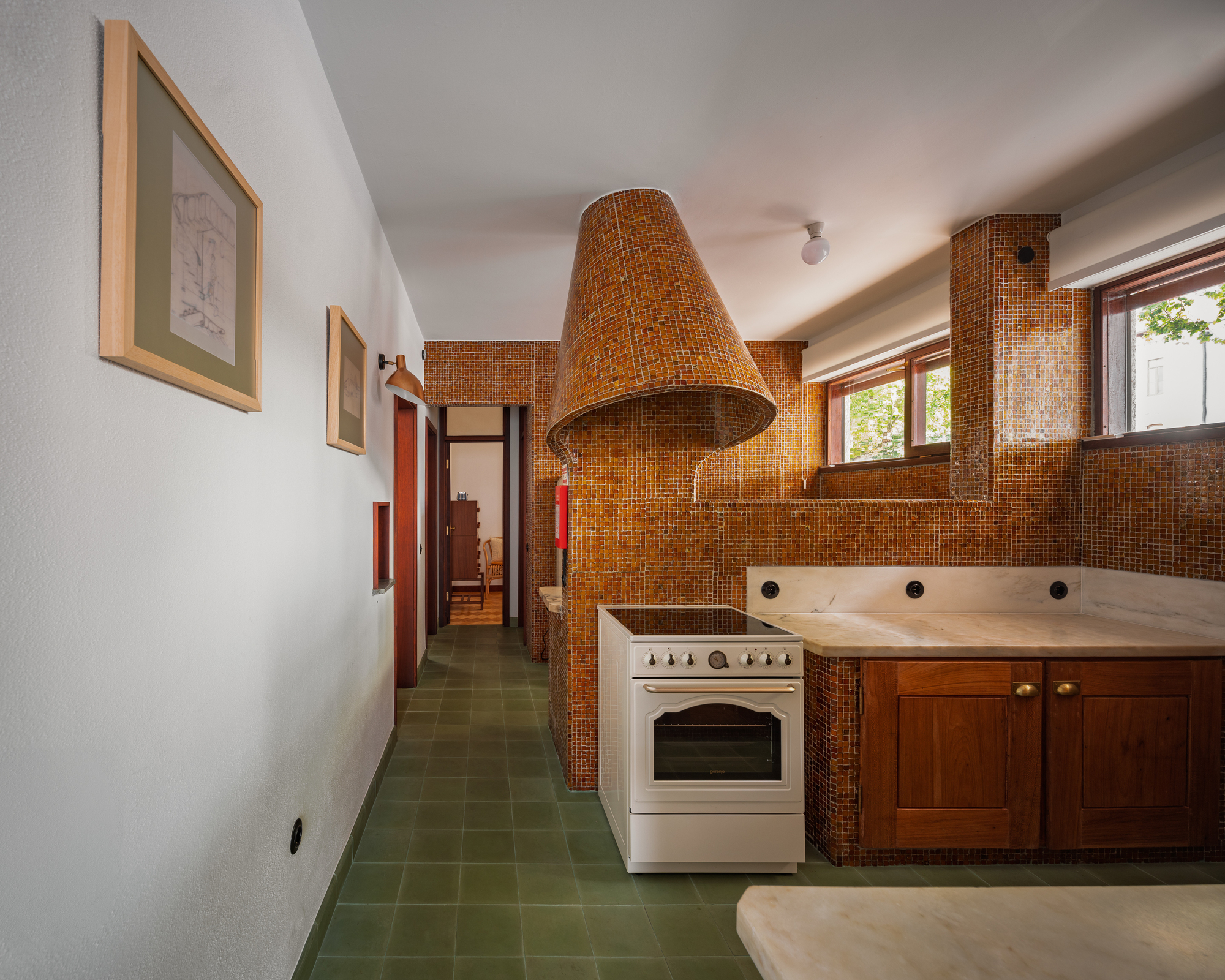 Kitchen with amber mosaic tile backsplash and conical woven exhaust hood above white range
