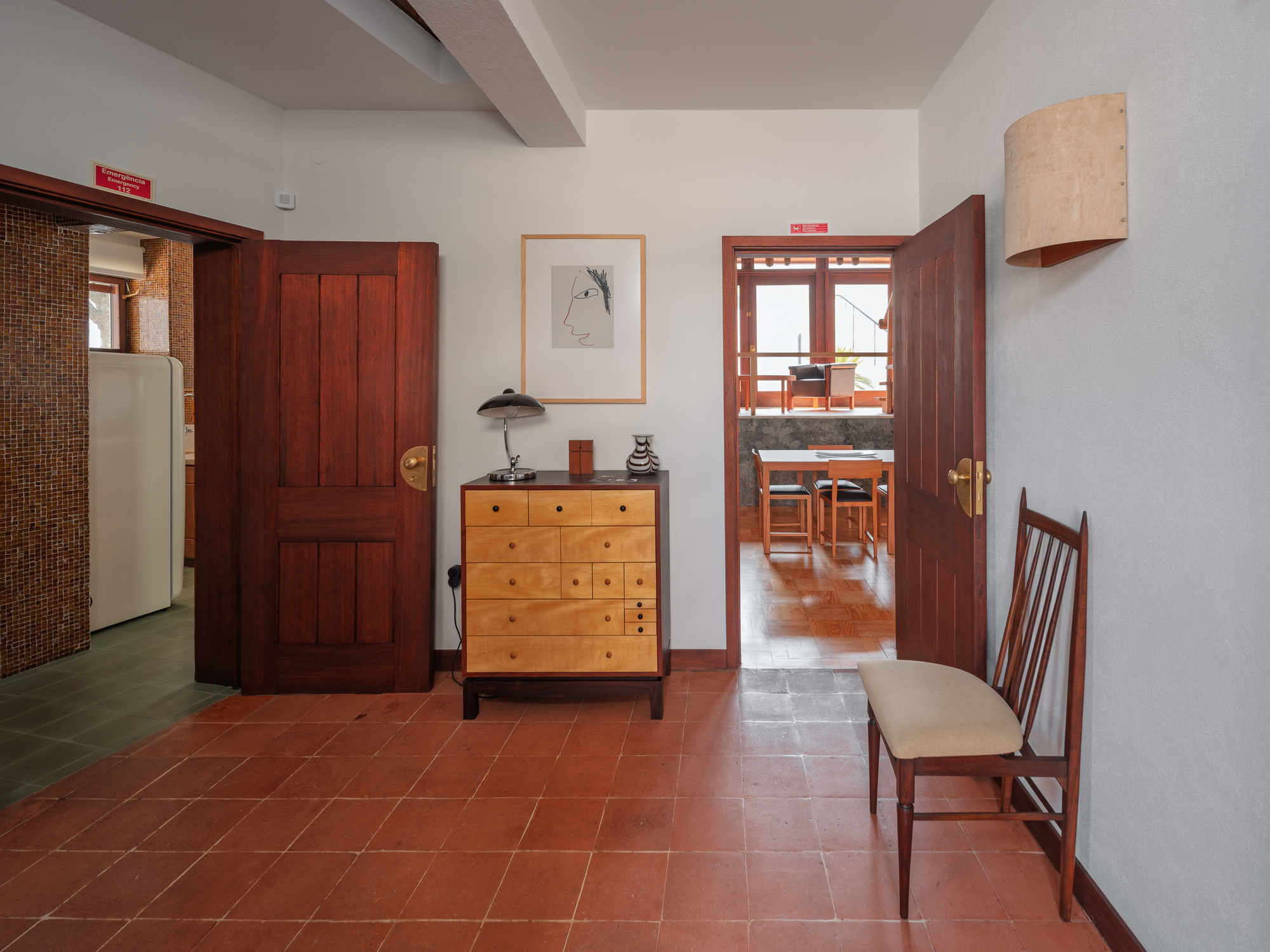 Entry hall with terracotta tile floor and dark timber doors opening into adjacent rooms