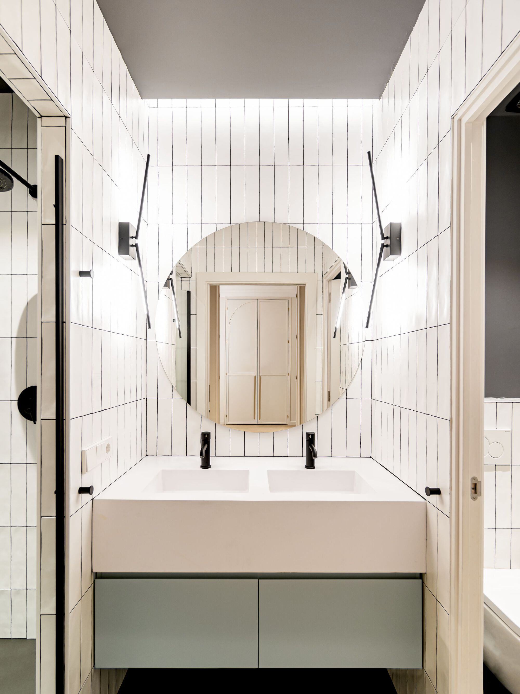 Bathroom vanity with white vertical tile walls, grey ceiling and arched mirror cabinet under paired sconces