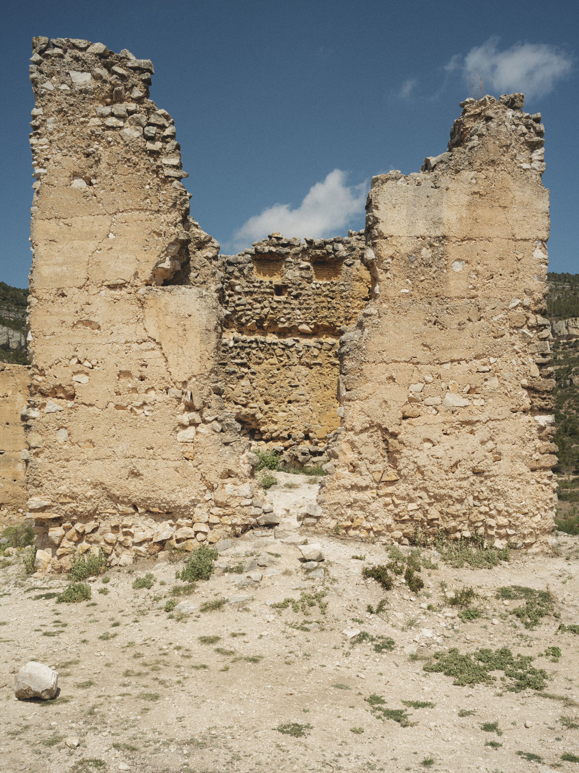 Ruined facade showing layered stone construction with exposed rubble core between two standing walls