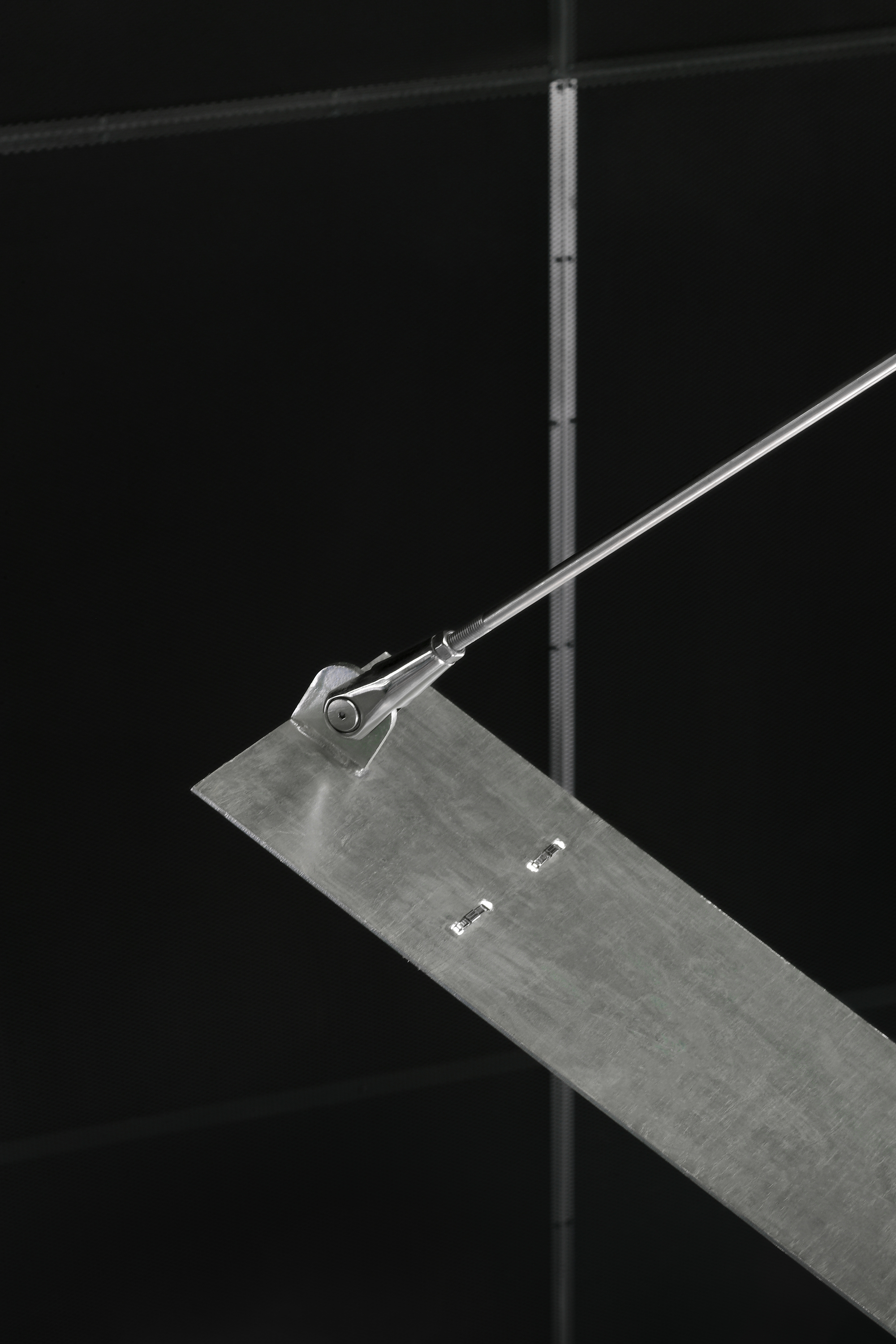 Close-up of a steel rod tensioner connecting to a concrete stair tread