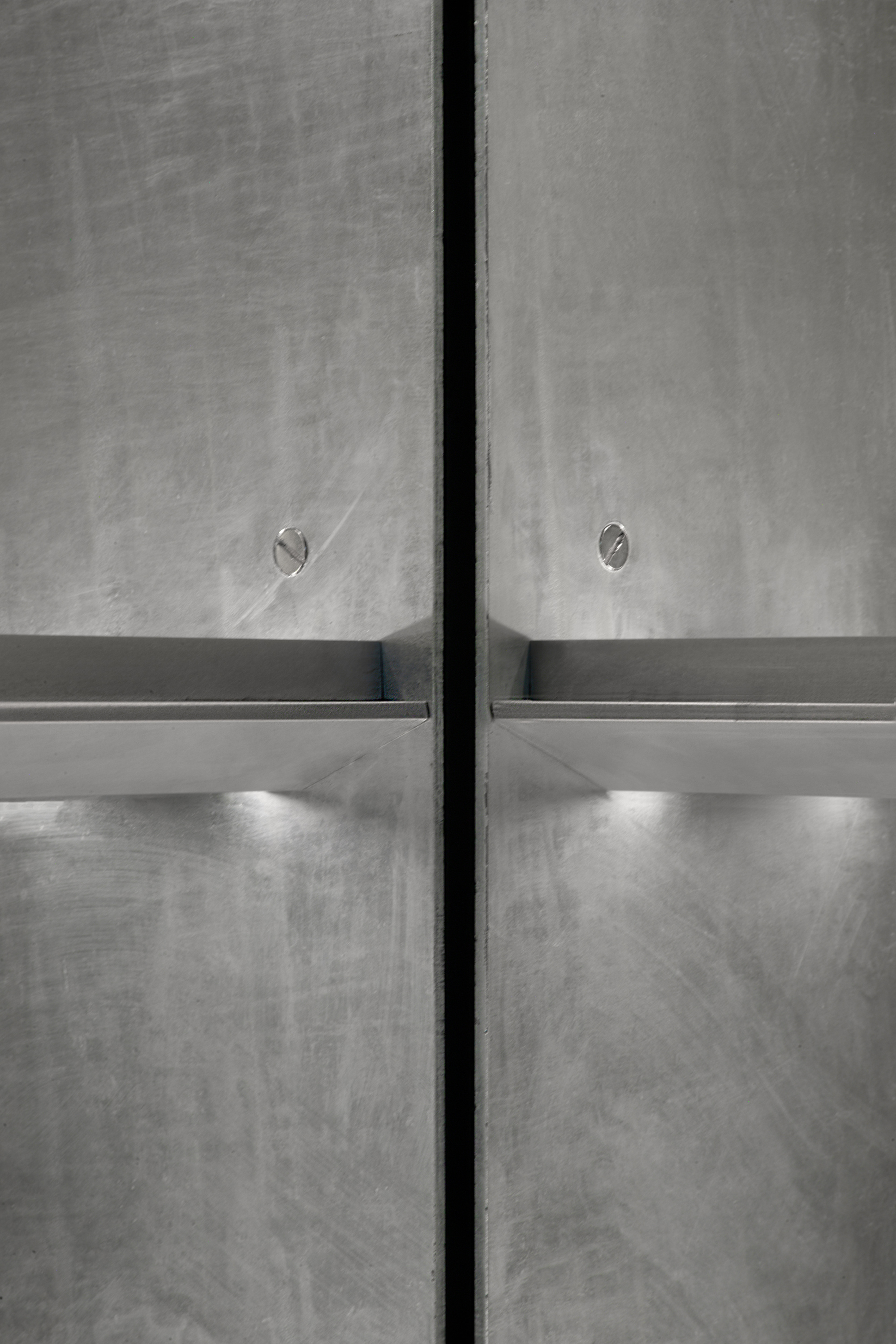 Close-up of concrete wall joint with horizontal metal ledge and integrated lighting below
