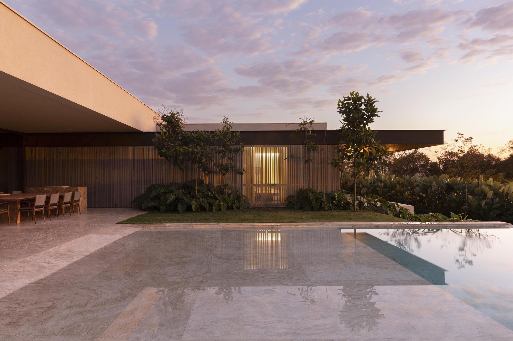 Pool deck with timber screen wall and reflecting water surface at twilight