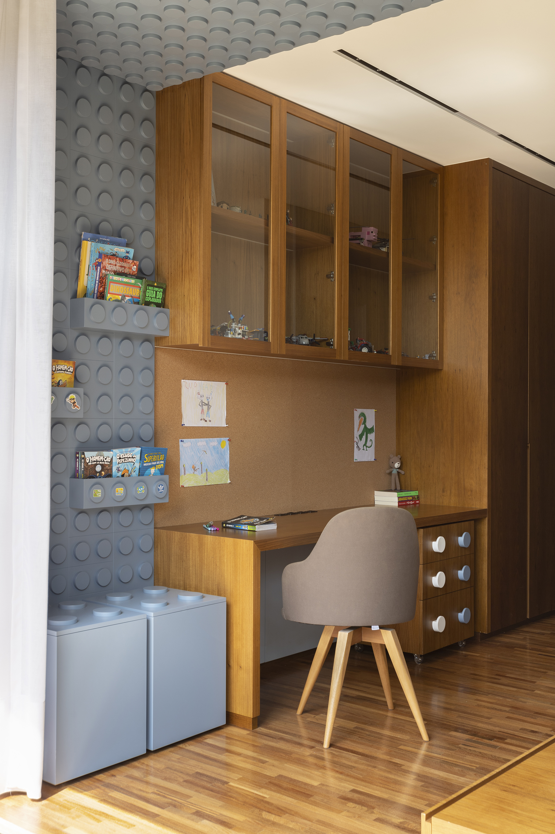 Built-in desk nook with timber cabinetry adjacent to a textured circular tile wall