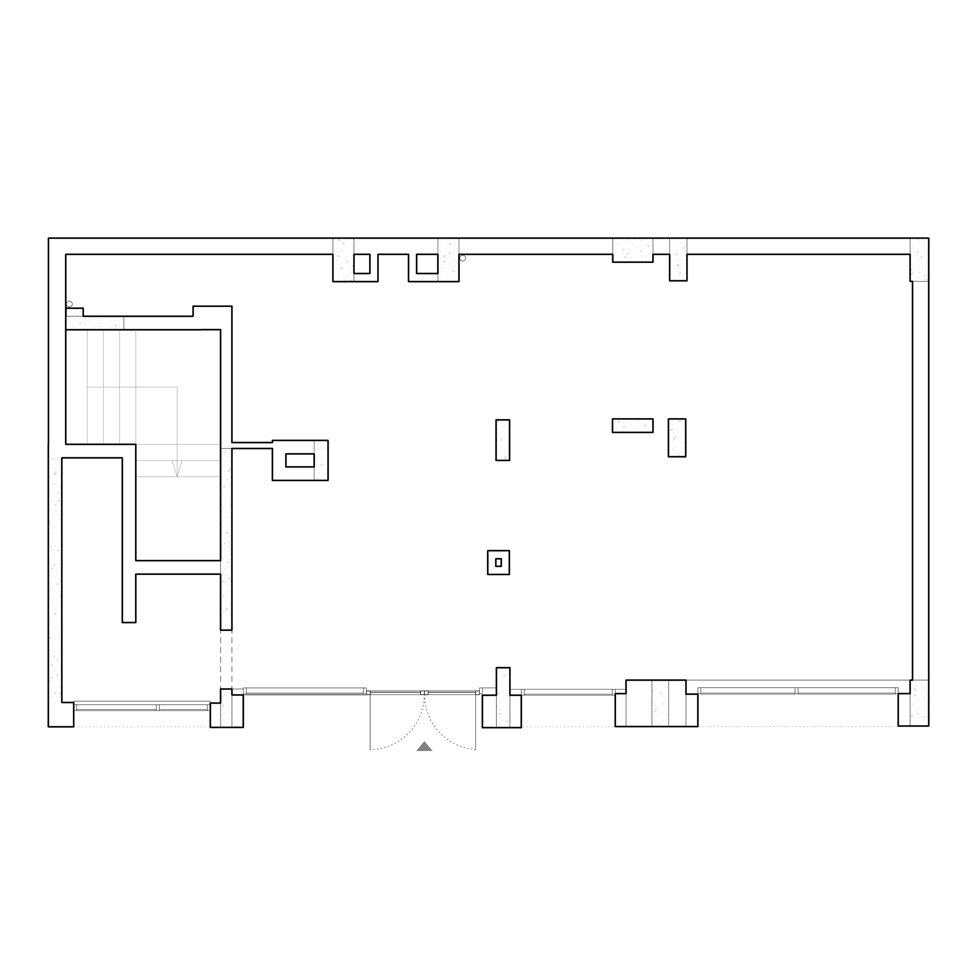 Floor plan drawing showing a large open space with a staircase and service areas along the left side