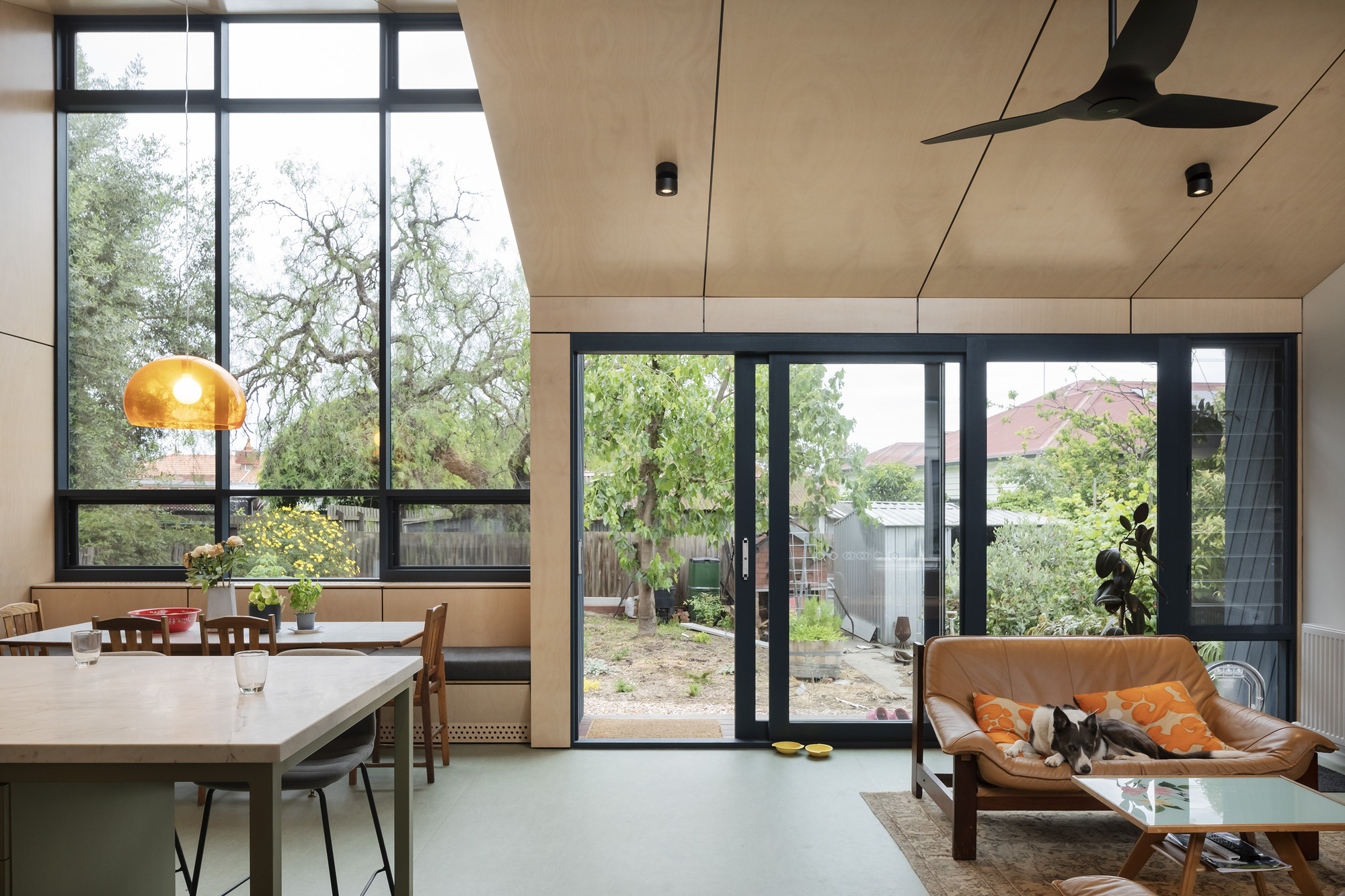 This architectural photo showcases a modern interior with a seamless blend of indoor and outdoor spaces. The design features large windows and sliding doors tha