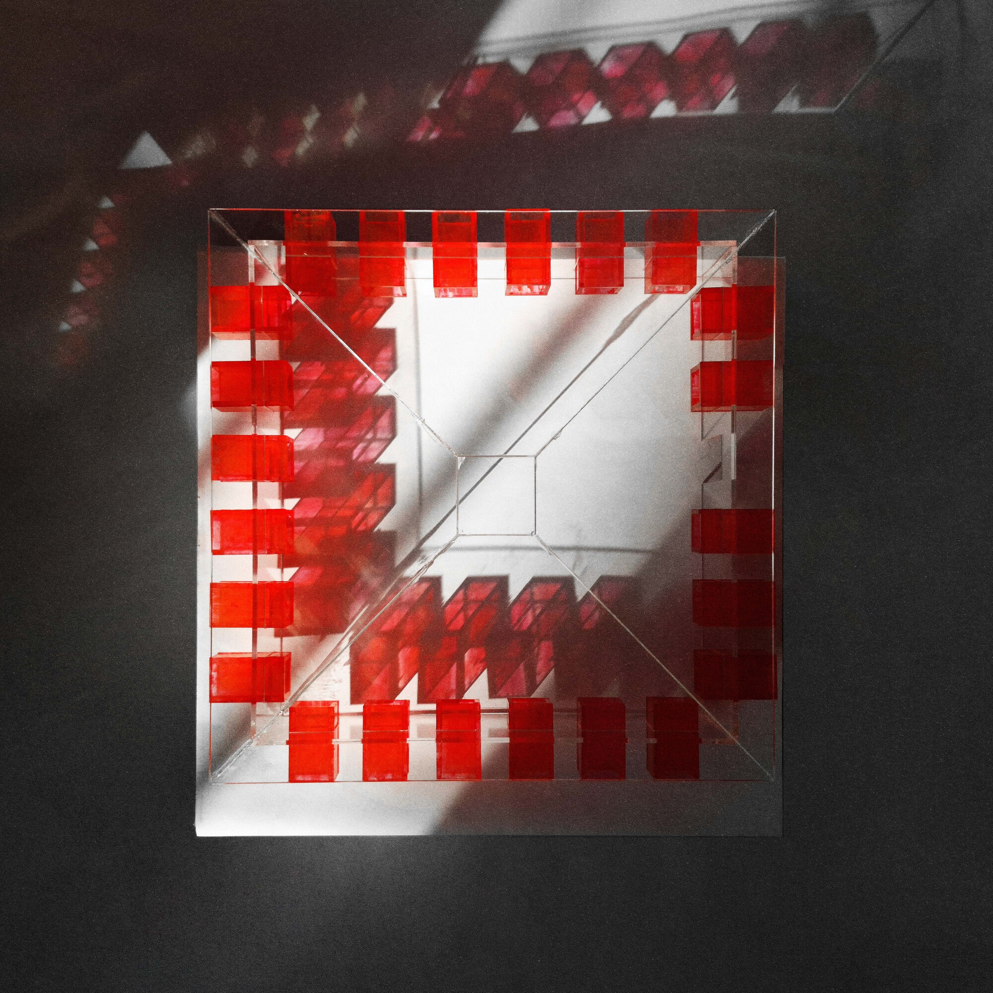 Top-down view of the model revealing the square courtyard surrounded by red programmatic blocks