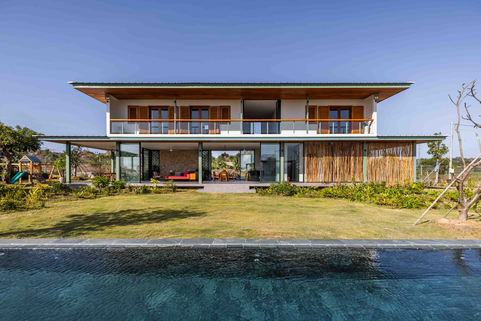 Two-story elevation across the reflecting pool showing open ground floor and enclosed upper balcony