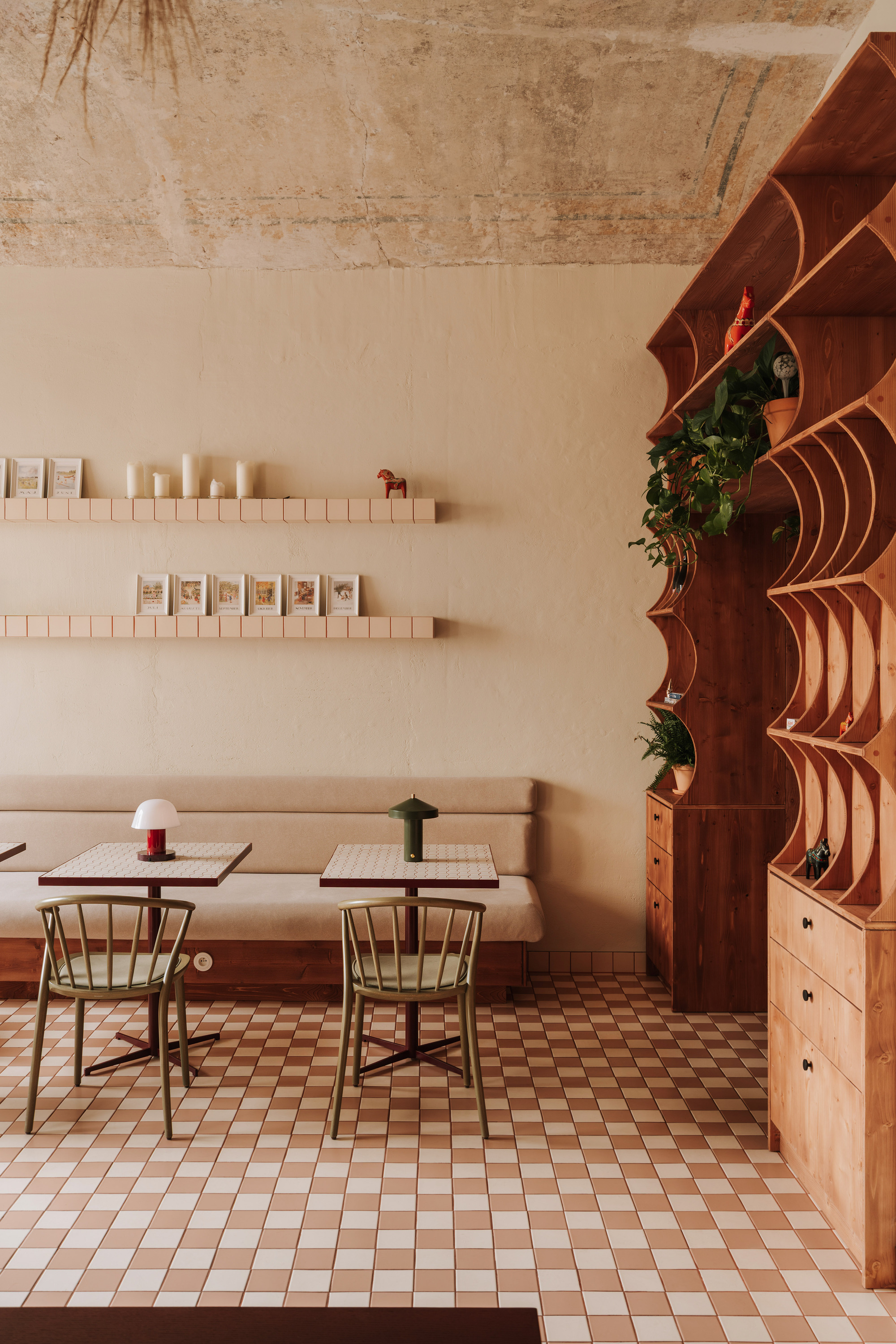 Dining area with chequered tile floor and curved timber shelving unit with integrated planters