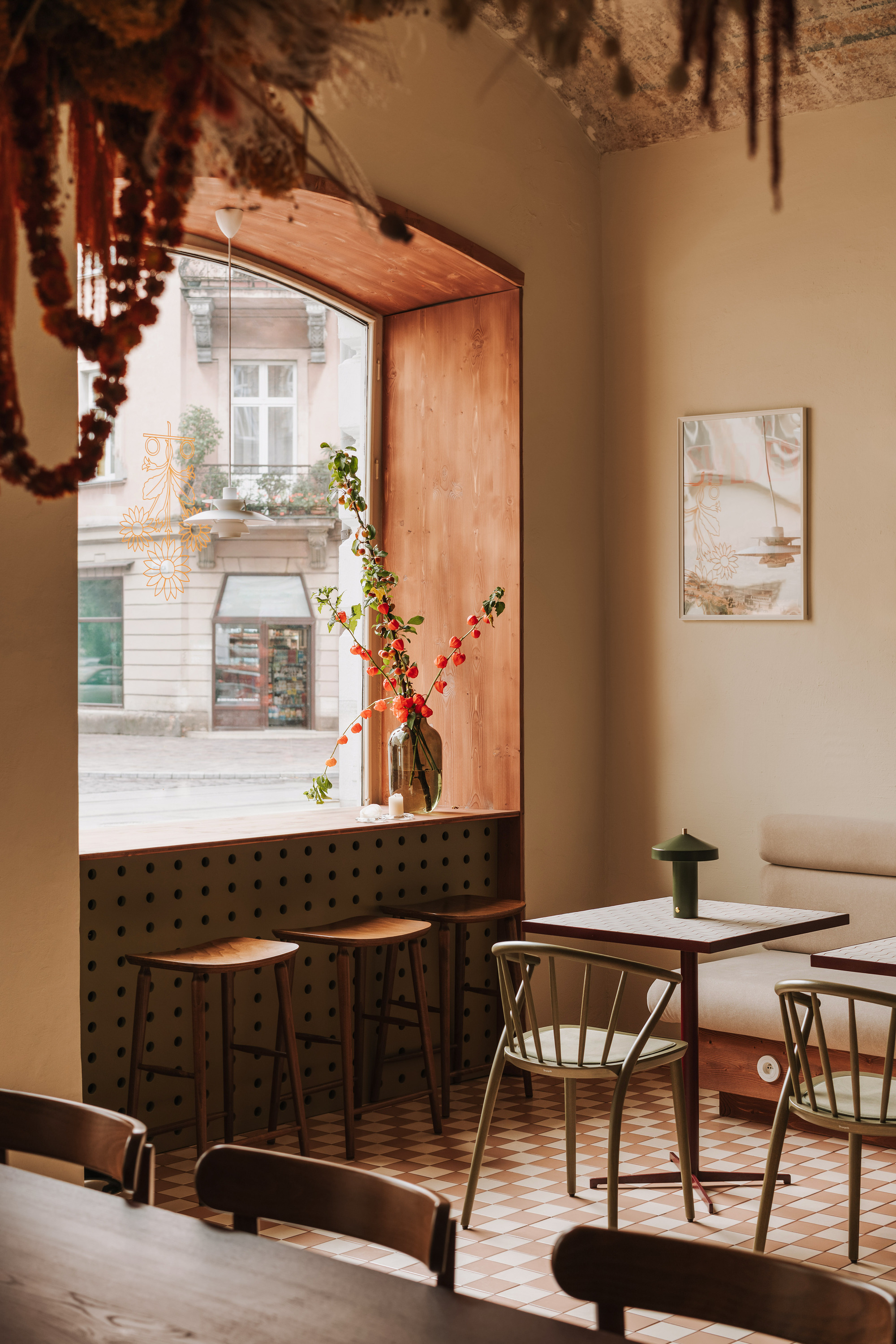 Timber-framed window nook with perforated metal panel and checkered tile floor overlooking the street