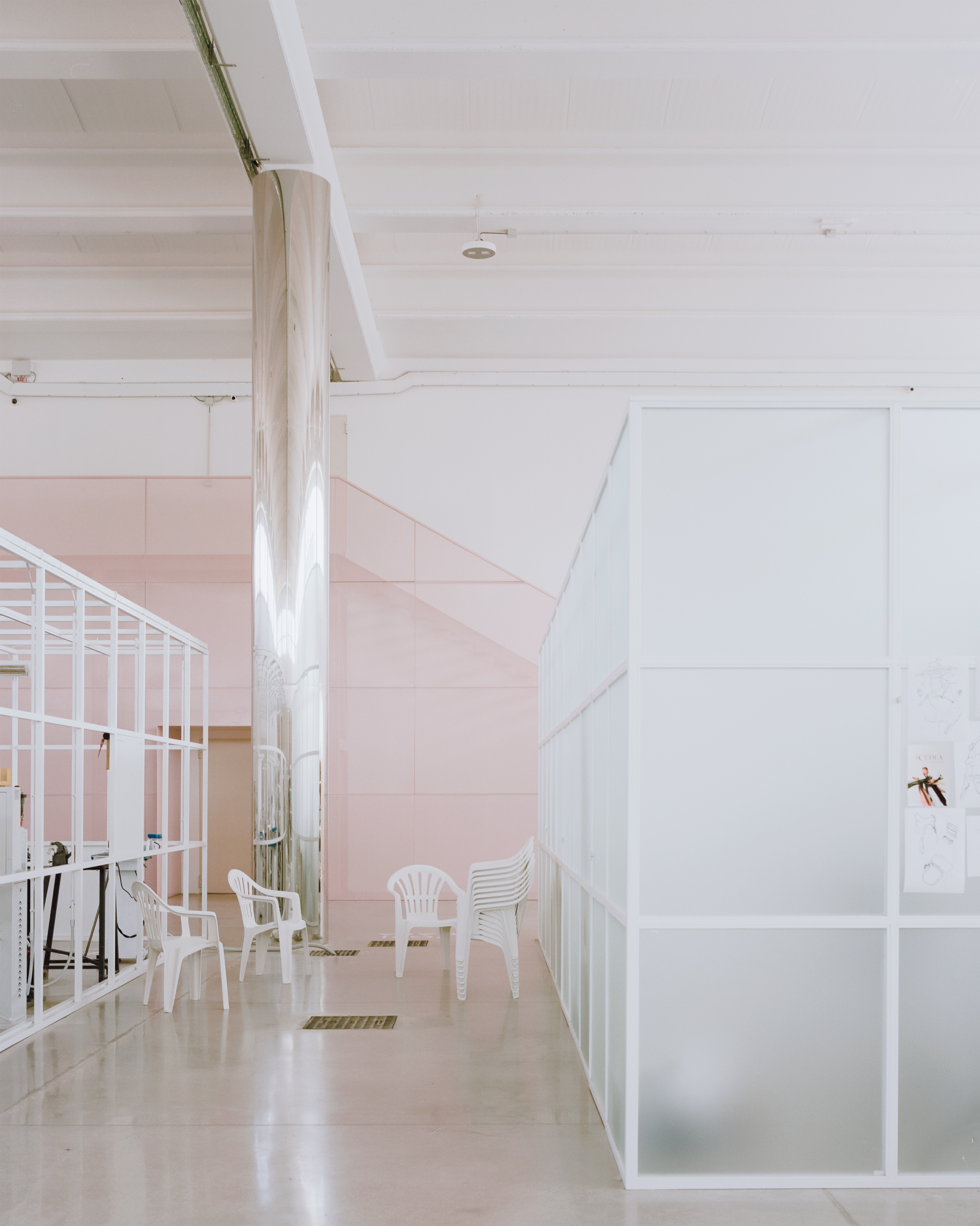 Polished concrete corridor with translucent white panels and pink tiled wall beyond