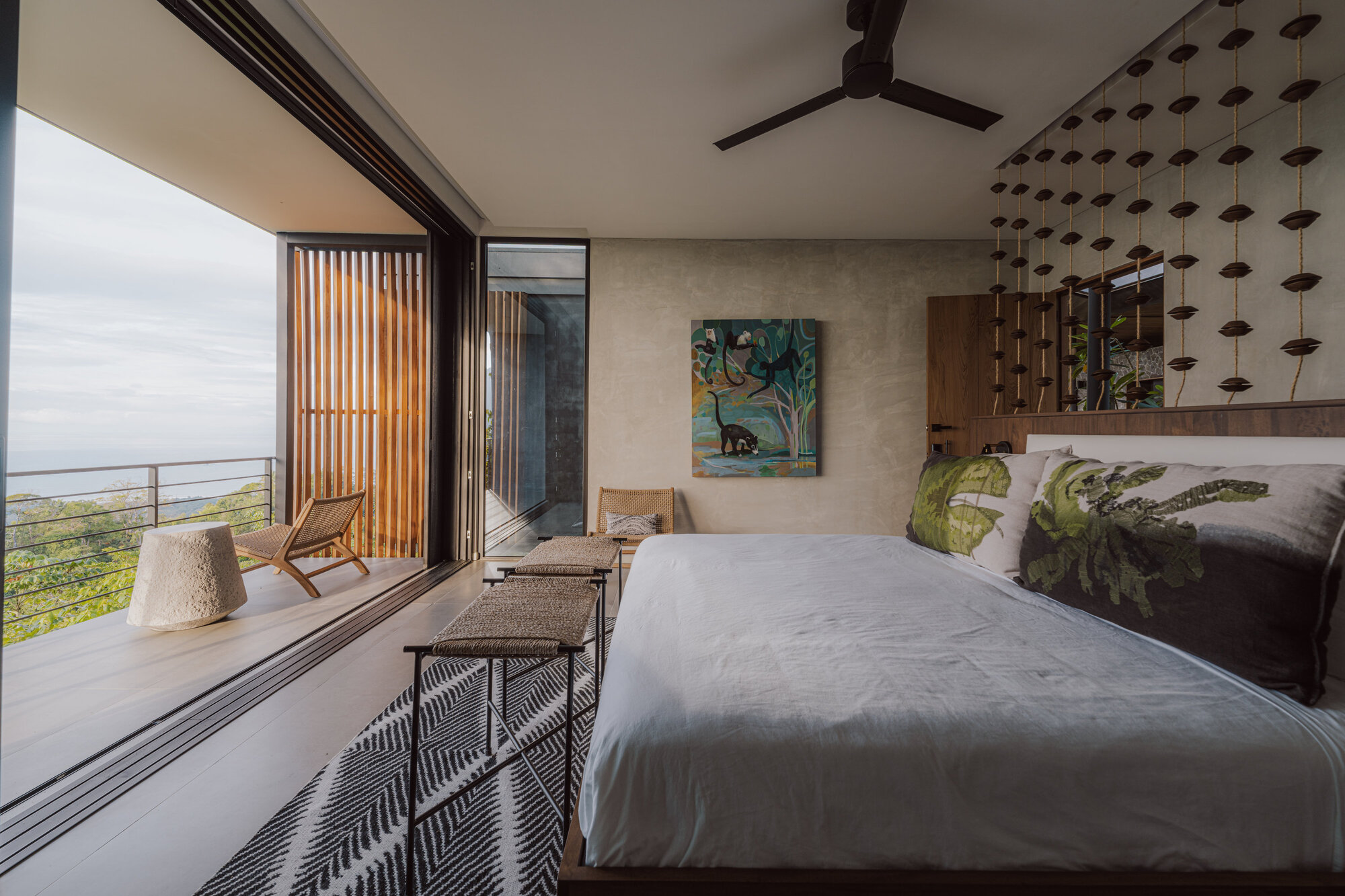 Bedroom with corner glazing, timber louver screen, and perforated panel headboard wall at dusk