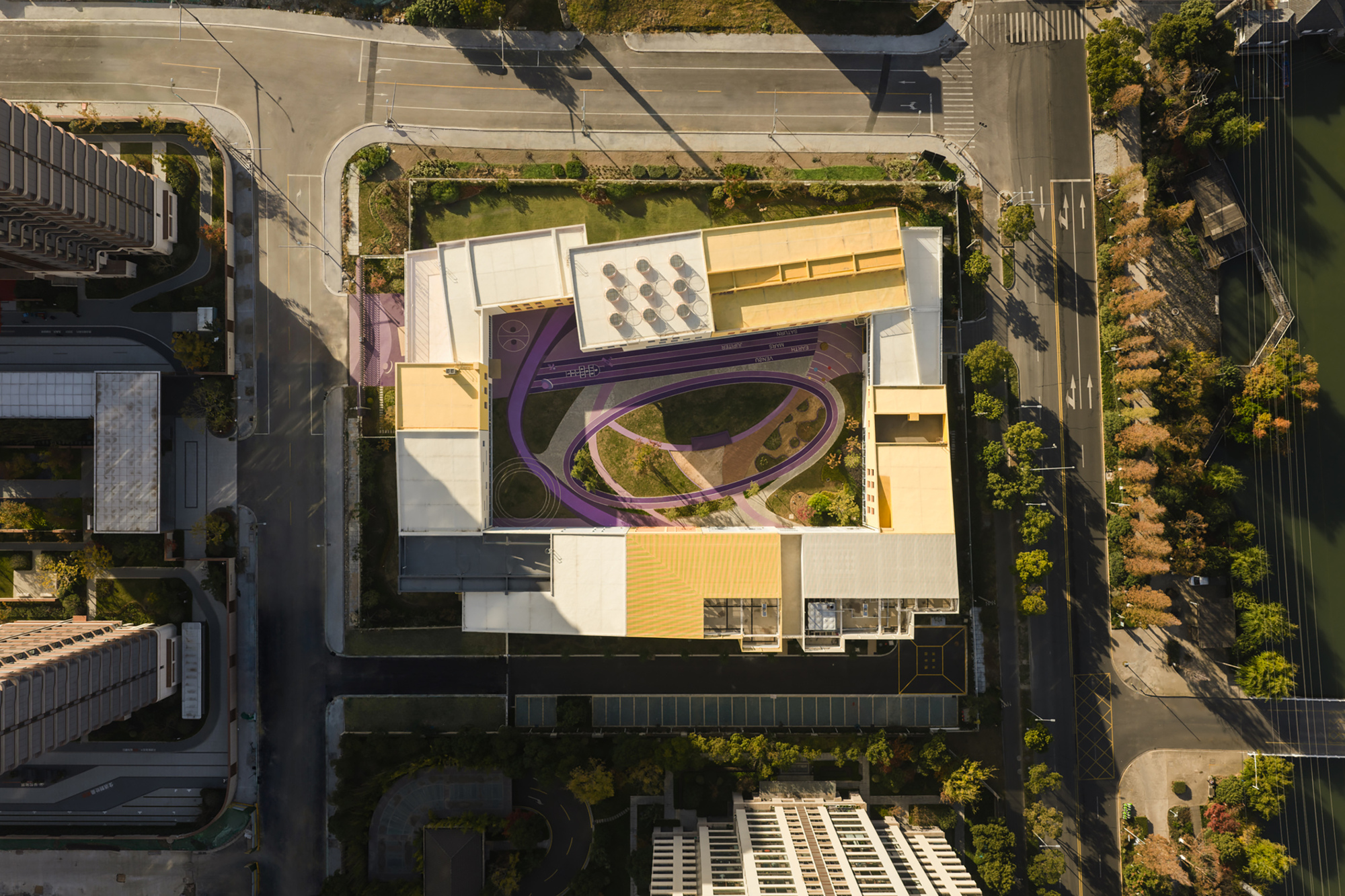Drone view of the rectangular perimeter plan with purple circulation pathway in the landscaped courtyard