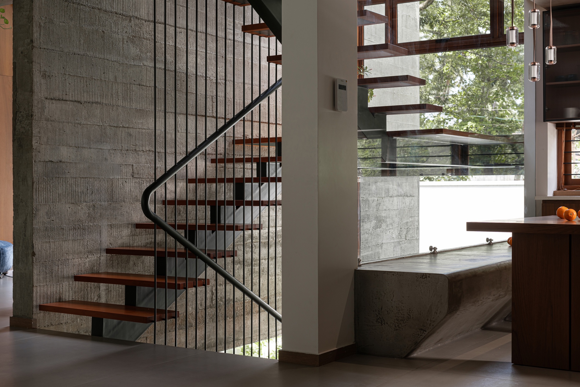 Curved staircase with timber treads and steel rods leading to an exterior terrace