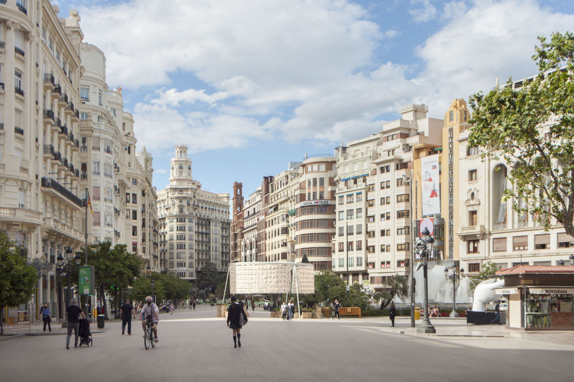 Temporary pavilion structure positioned in a public square surrounded by historic apartment buildings