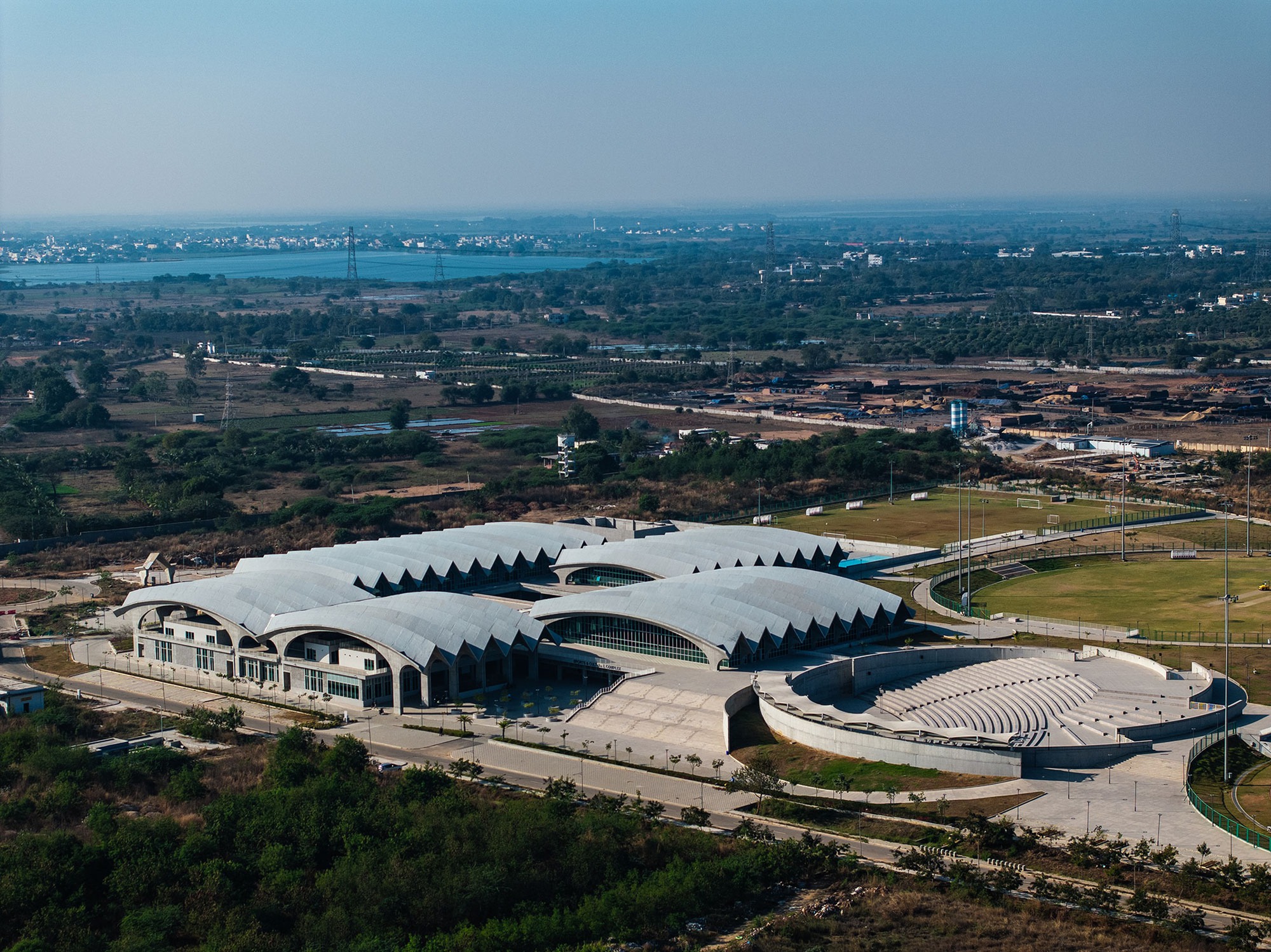 Aerial view of the serrated concrete roof with circular opening set in surrounding agricultural fields