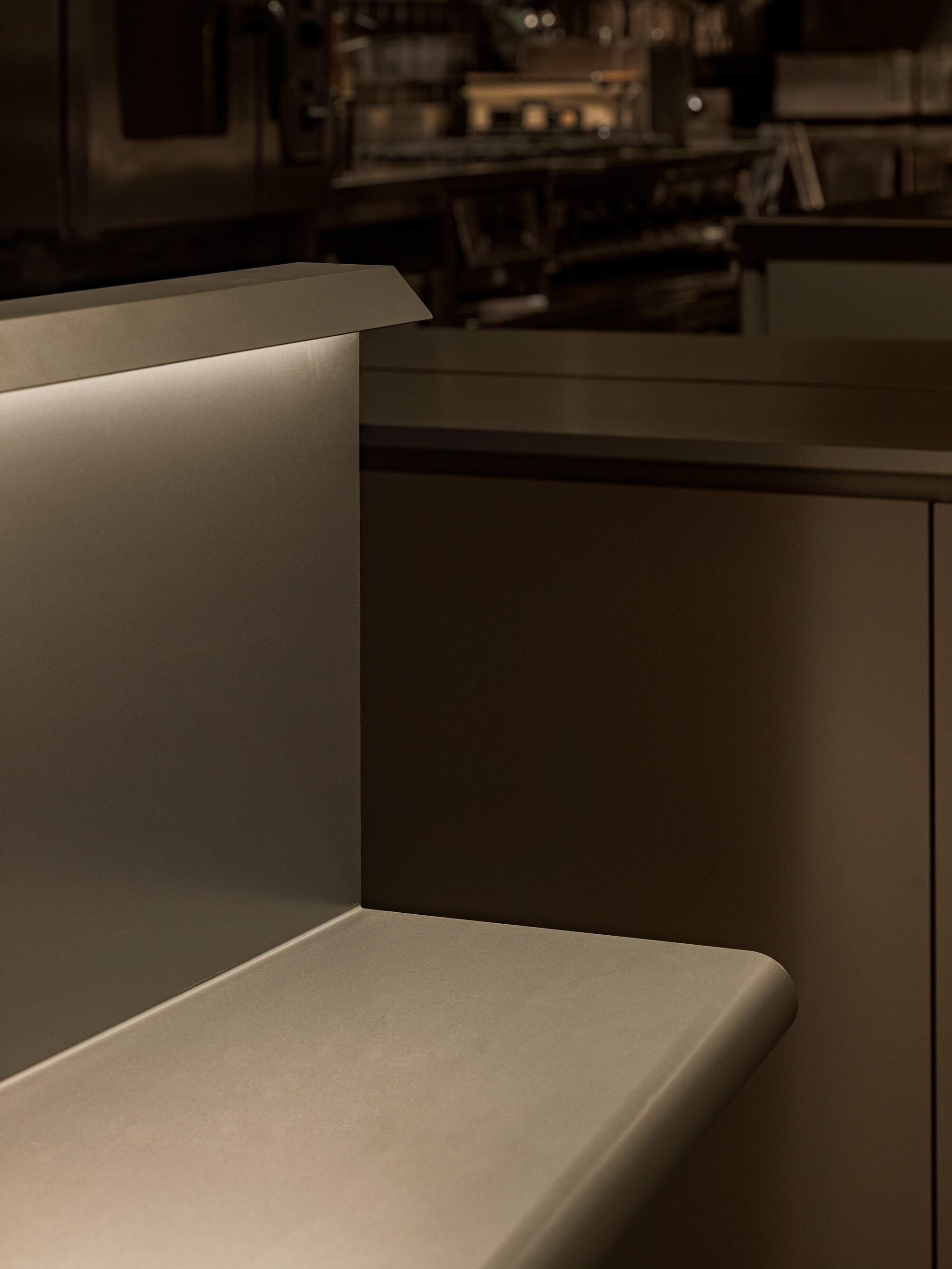 Detail of upholstered banquette seating with recessed LED strip lighting at the edge