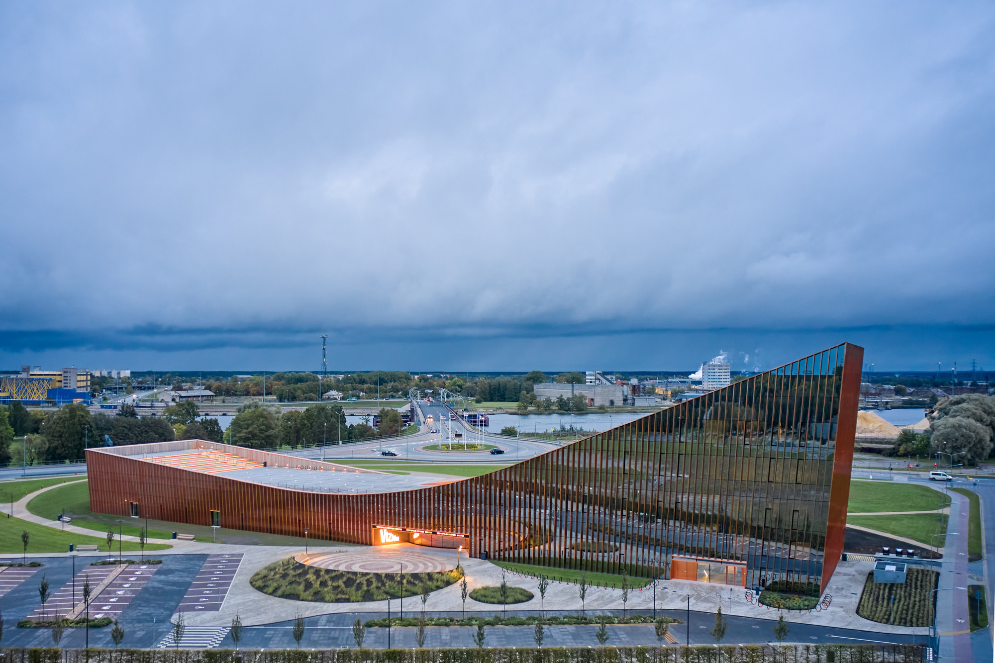 Aerial view of the undulating planted roof and vertical timber screen under overcast skies