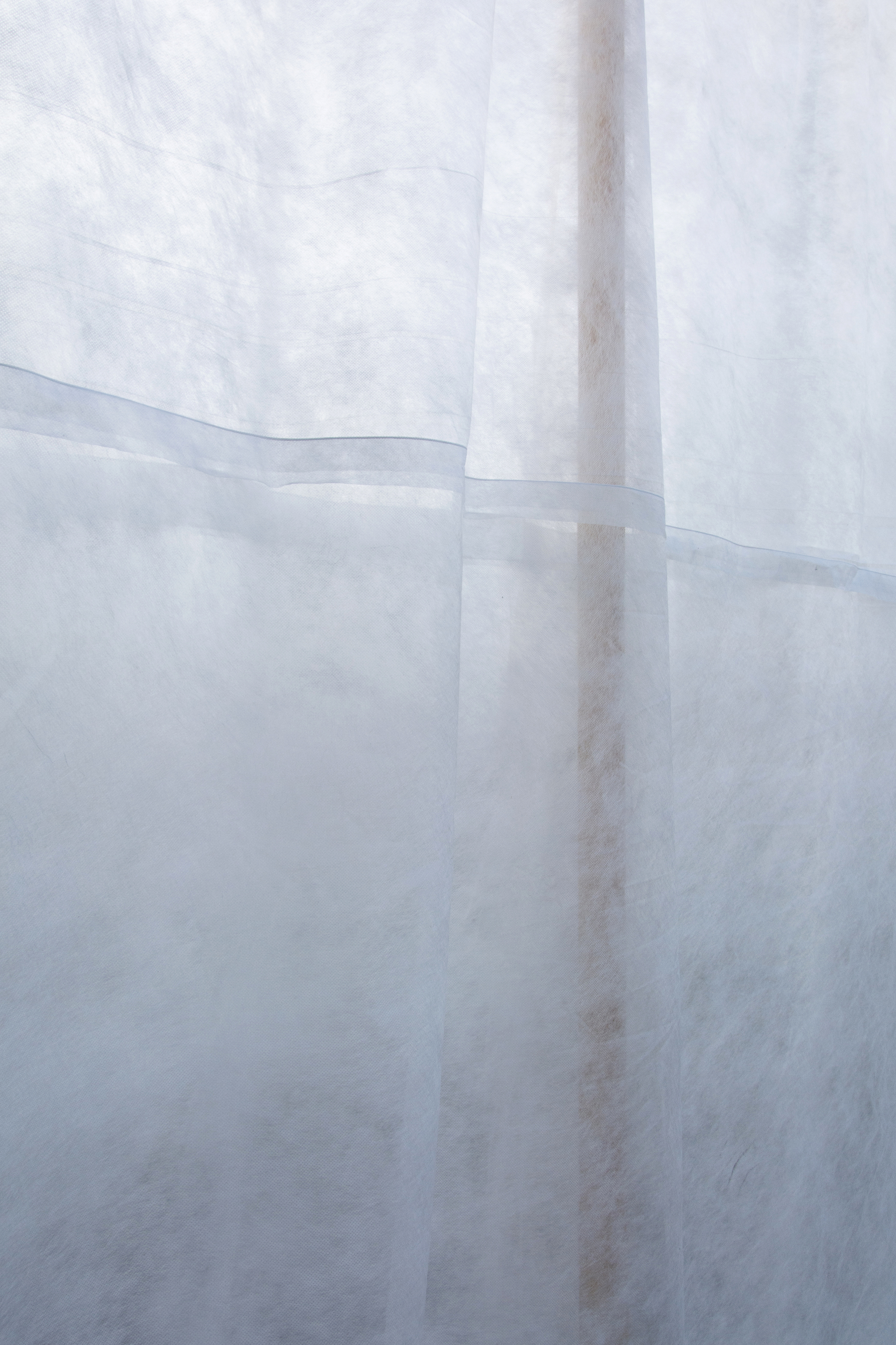 Close-up of overlapping translucent fabric panels showing seams and variations in texture