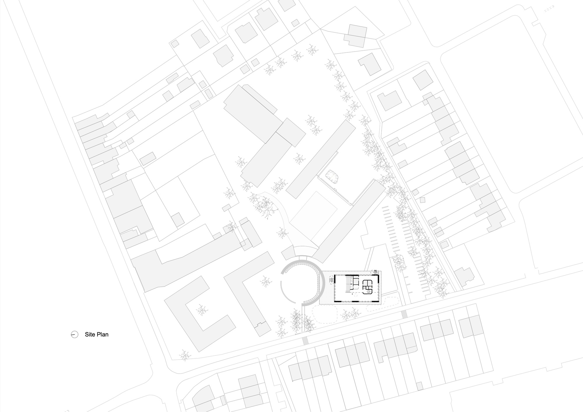 Site plan drawing showing the building footprint with circular element and surrounding residential streets and parking areas