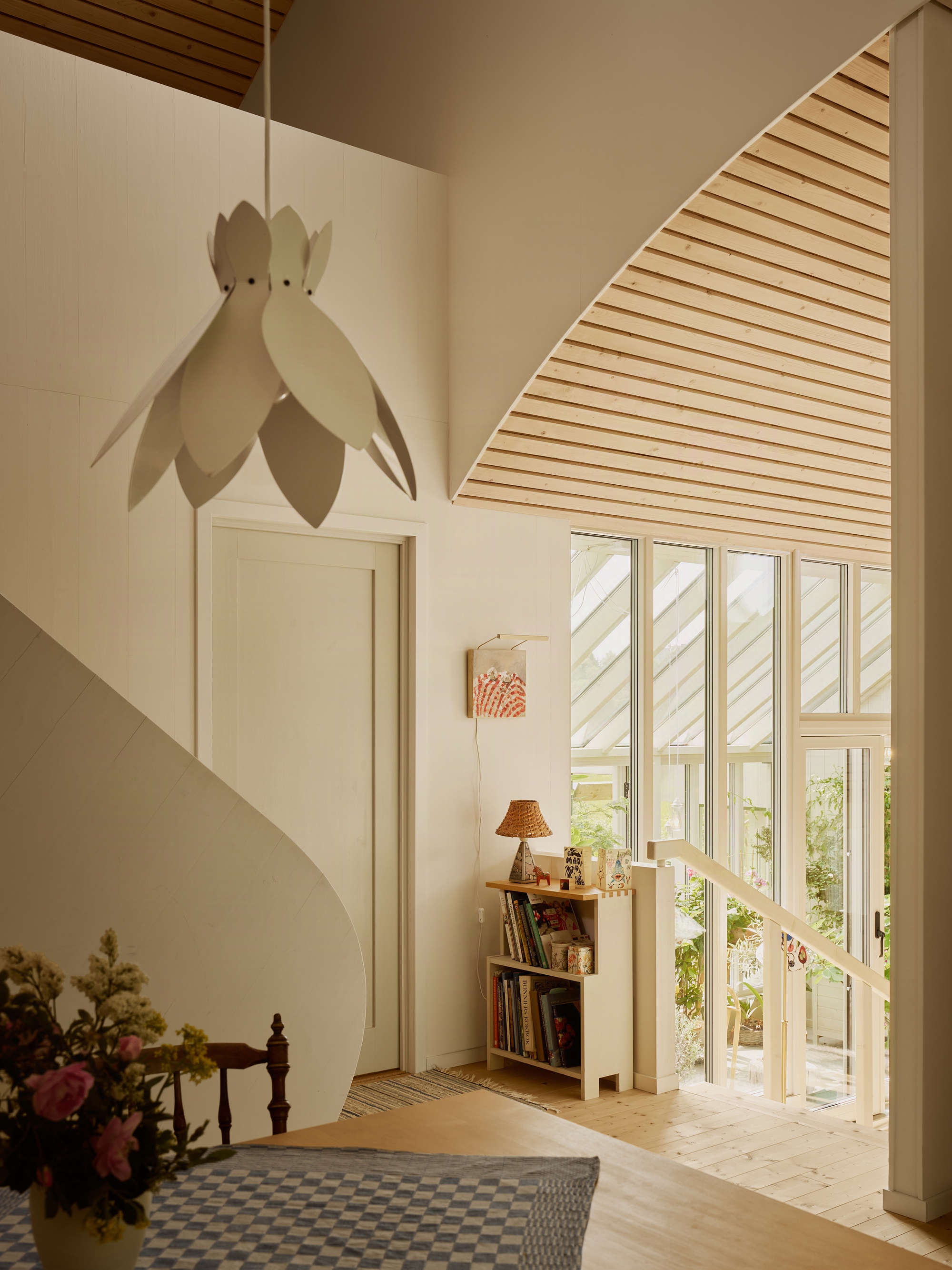 Stairwell with triangular skylight, white petal pendant lamp and gridded tile floor pattern