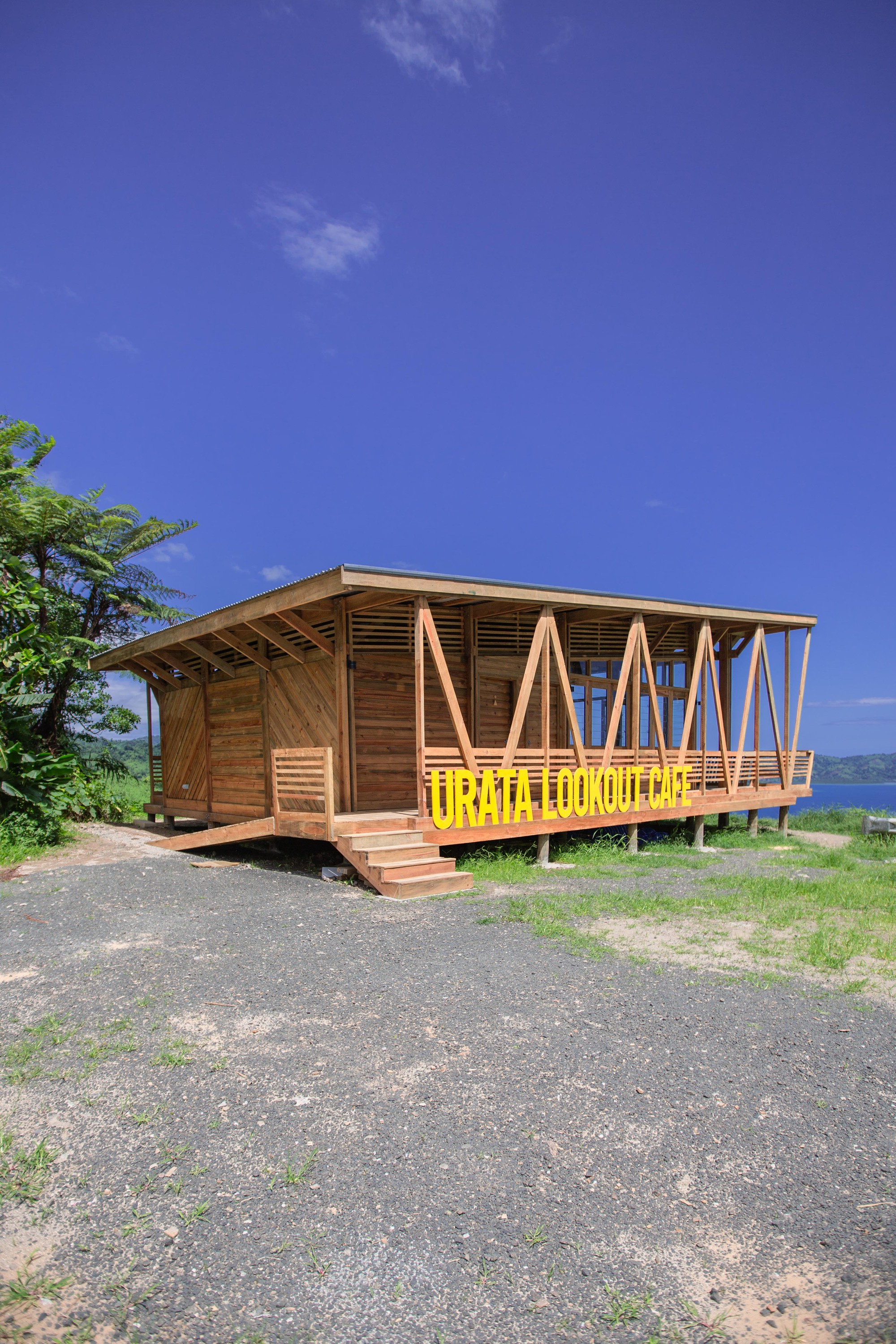 Side view of the elevated wooden pavilion with asymmetric pitched roof and open diagonal framing