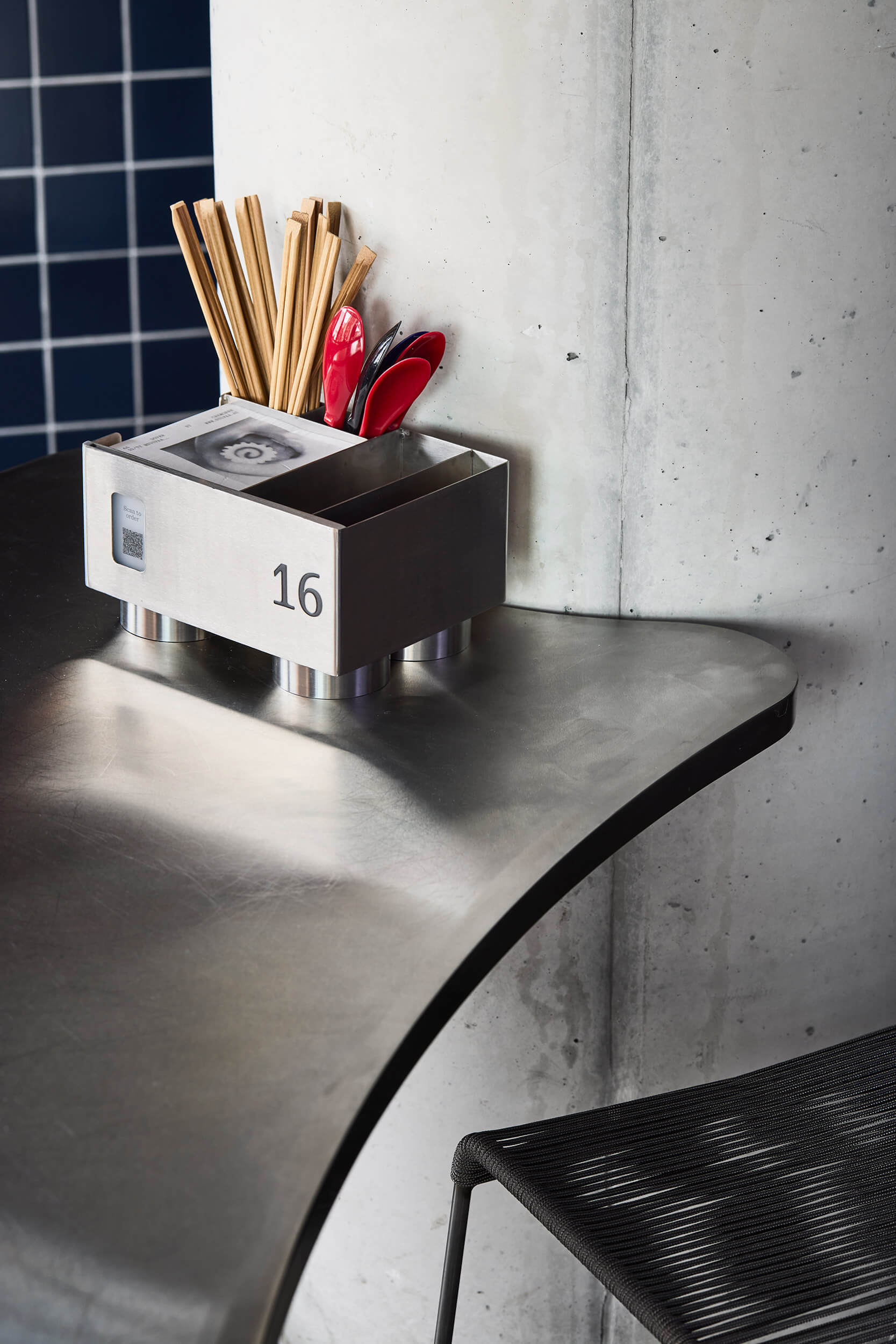 Numbered organizer box on curved countertop beside concrete column in afternoon light