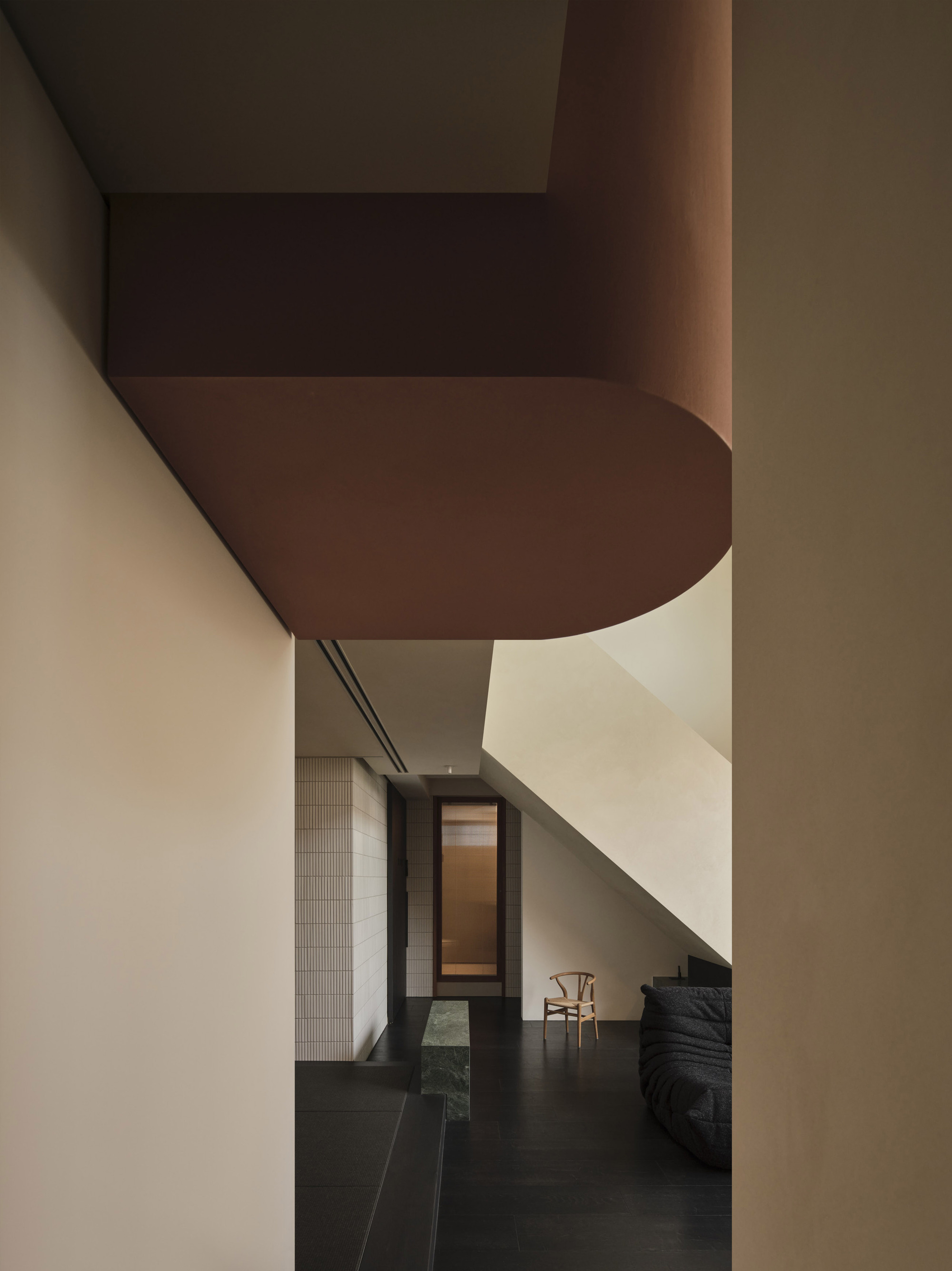 View through doorway showing rounded soffit detail and dark floor tiles in afternoon light