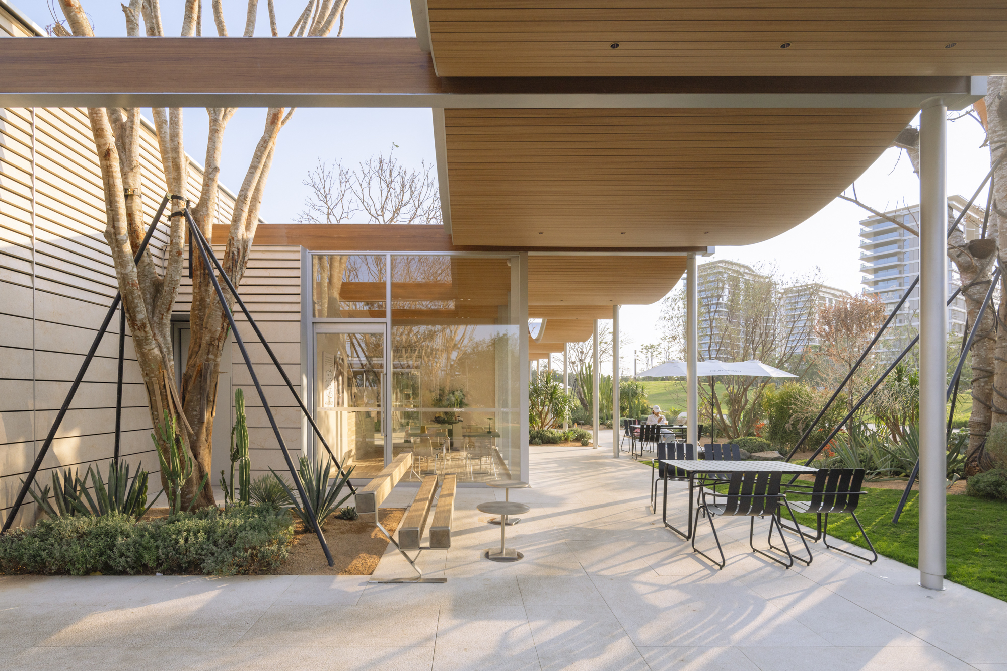 Covered outdoor patio with wood soffit looking through glass doors to bare winter trees