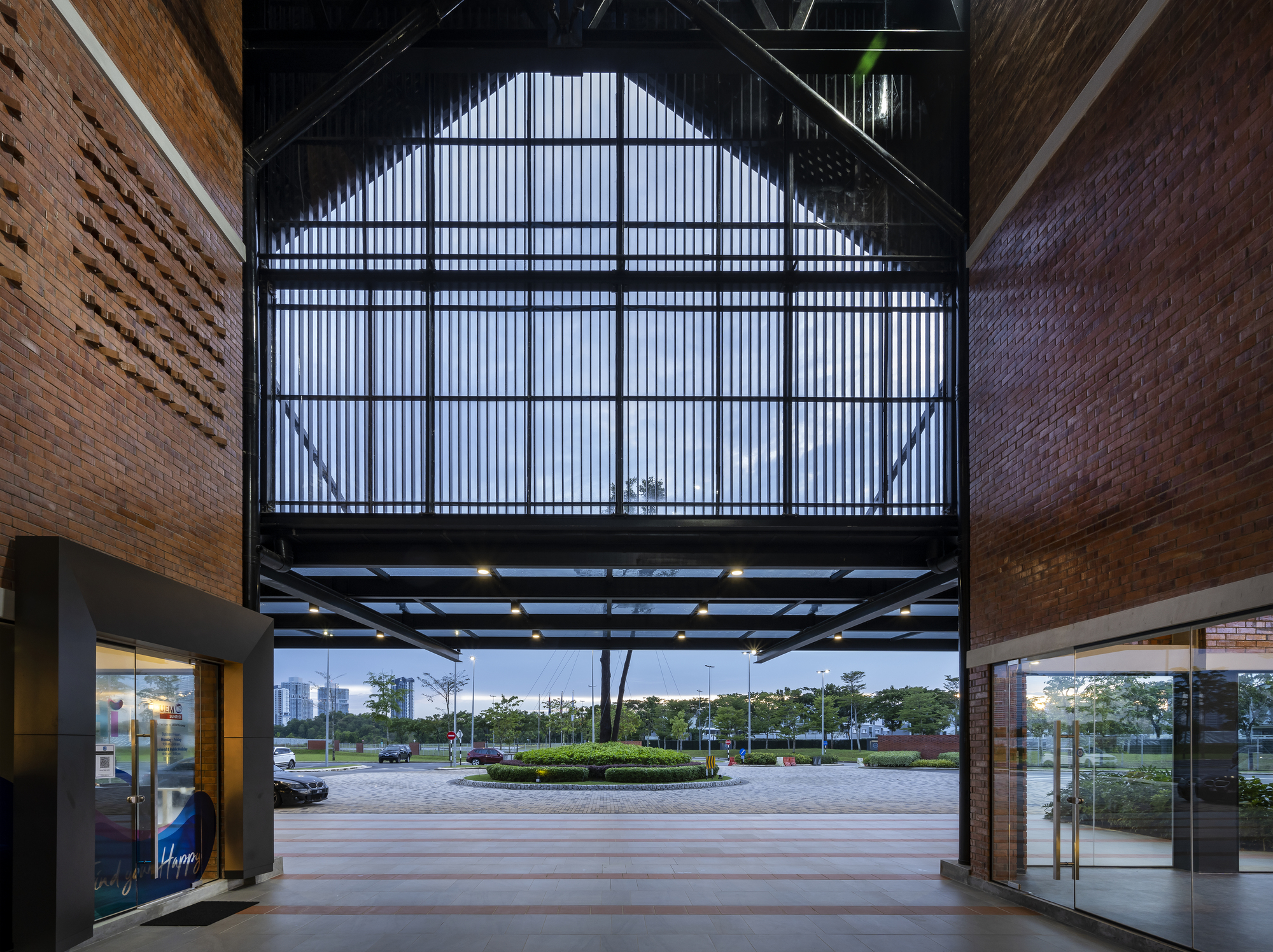 Interior atrium view with translucent corrugated wall and steel framing at twilight