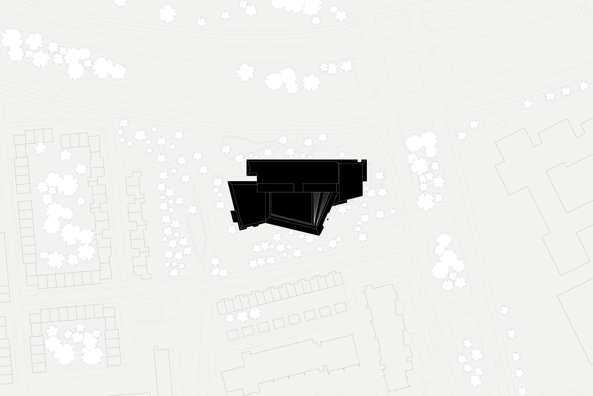 Site plan drawing showing the angular building footprint surrounded by trees and neighboring structures