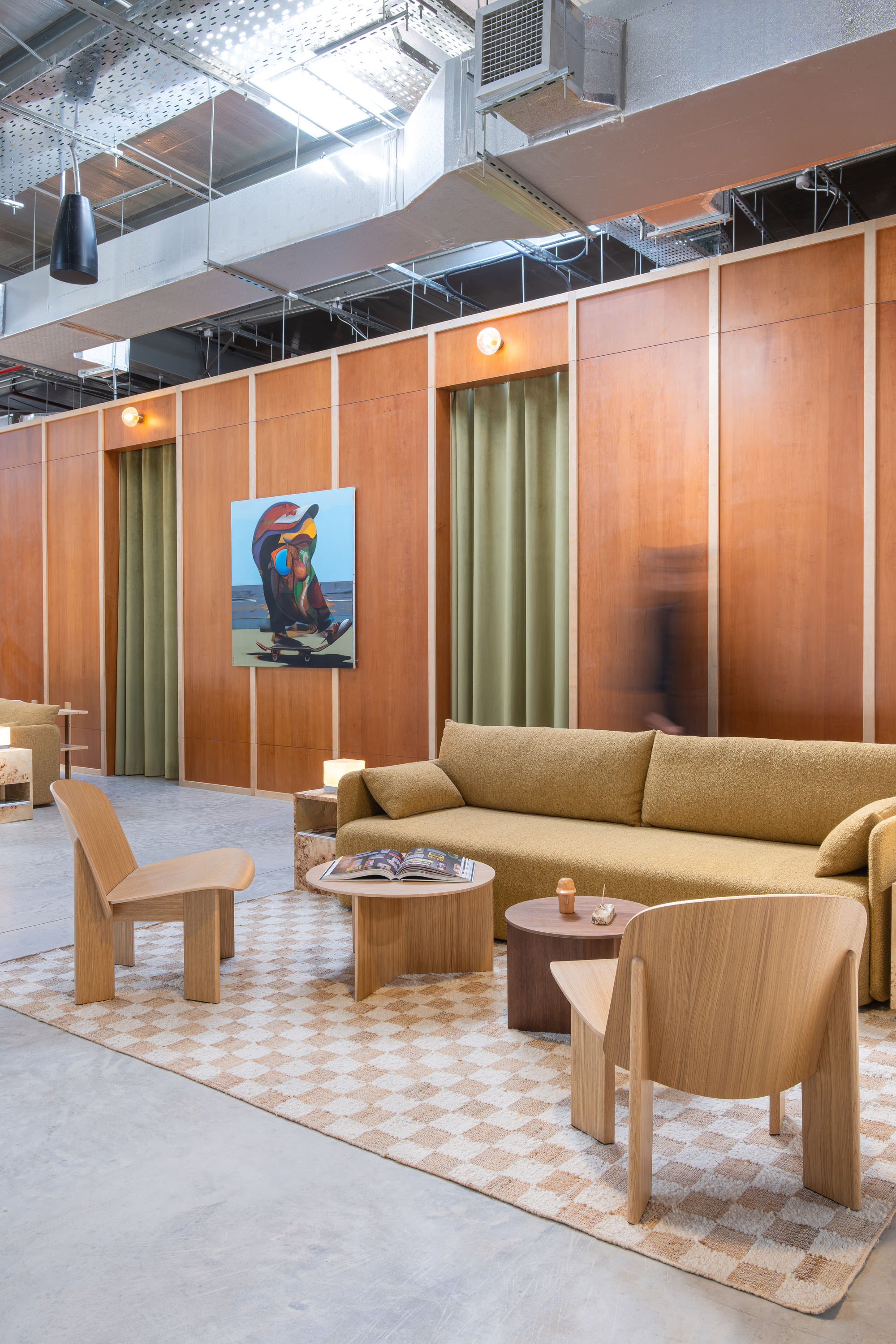 Timber paneled wall with olive curtains and warm pendant lighting in a lounge area