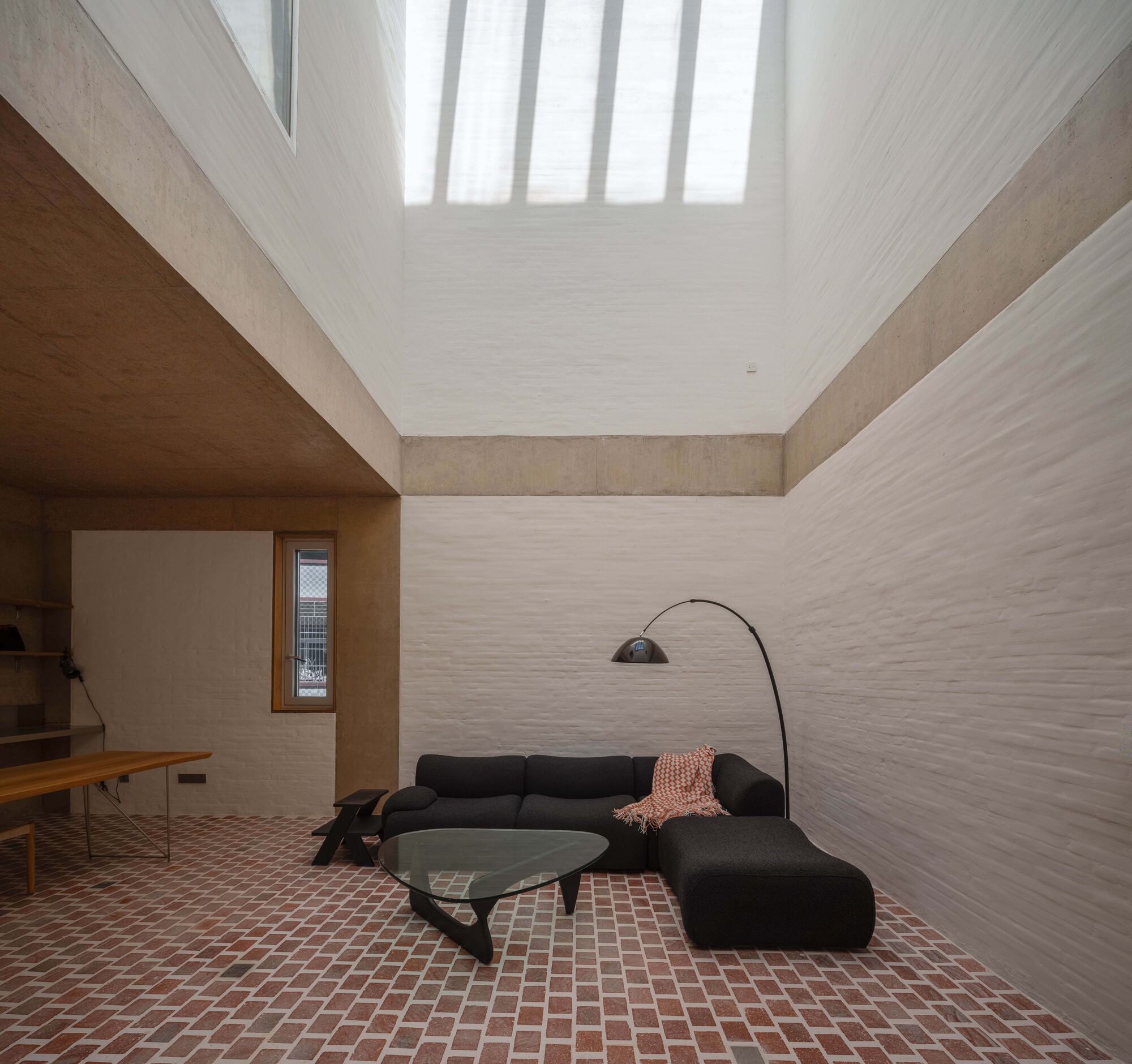 Interior courtyard space with terracotta tile floor and vertical skylight slats diffusing natural light