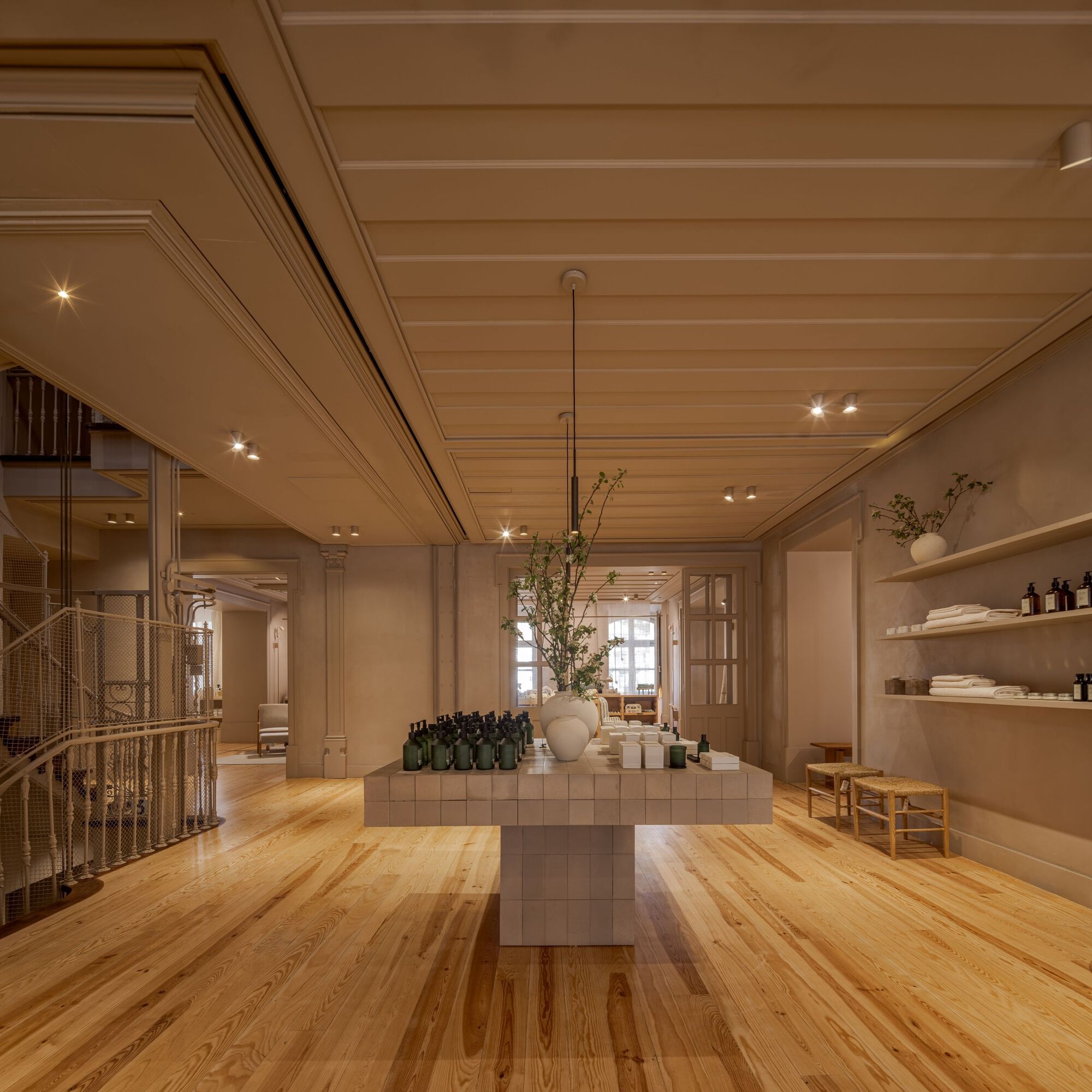 Interior retail space with tiled display table, wood plank flooring, and recessed ceiling lighting