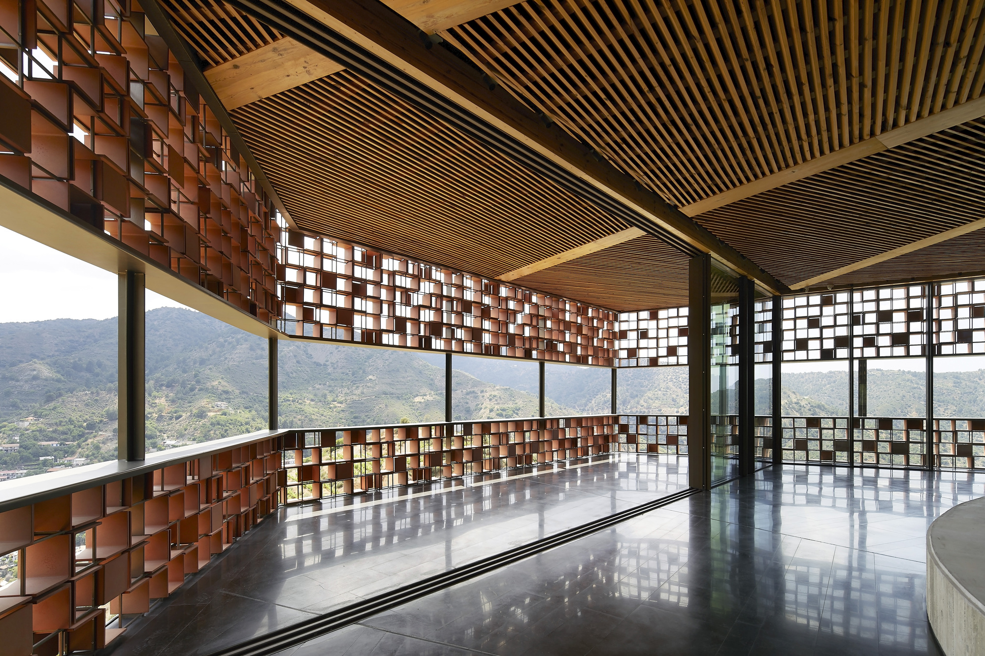 Interior space with timber batten ceiling, mosaic screens and polished floor reflecting mountain views